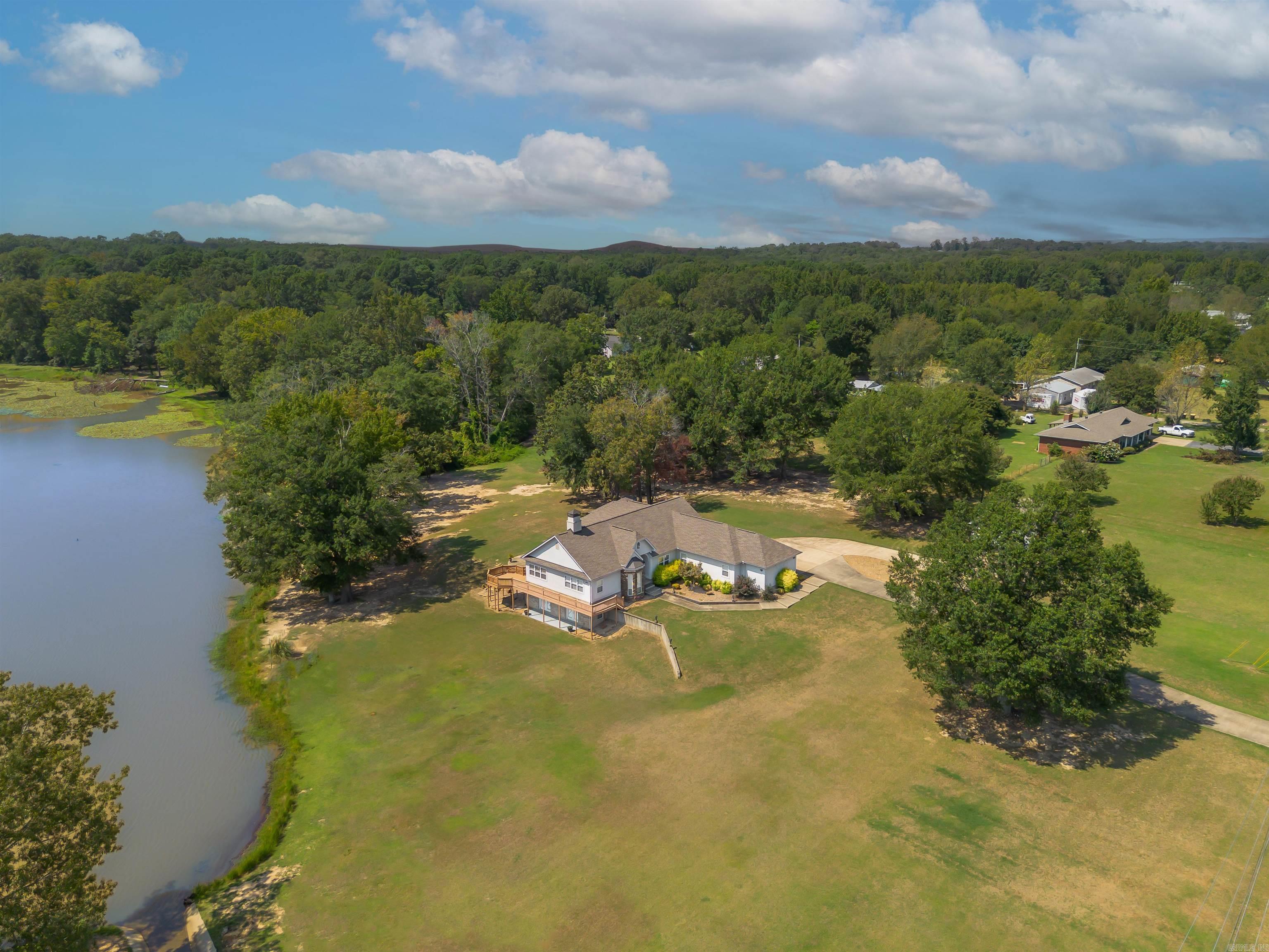 Custom-Built Home on a Private Oasis! This 4,439 SF home resides on 3.37 lush acres with picturesque pond and breathtaking views! The Main Living Space in this residence features 3 Bedrooms, 2.5 Bathrooms, Bonus Room, Living Room, and Sunroom with perfect views of the property! The gourmet Kitchen/Dining is a chef’s dream—complete with custom cabinetry, breakfast bar, high-end stove/oven, and abundant storage! Step outside to expansive decks and patios, ideal for entertaining or simply relaxing in the beauty of nature. The Lower-Level Suite includes full Kitchen, Family Room, Bedroom, Bath, Laundry and walk out to a private patio—perfect for guests or multi-generational living! Plus— an oversized Storm Shelter! BONUS—832 SF additional Building on the property—great for storage with potential to renovate as a guest house! Newer Roofs on main house and additional building (2022)! The possibilities are endless with this rare find! Don’t miss your chance—schedule your showing today! Agents see remarks.