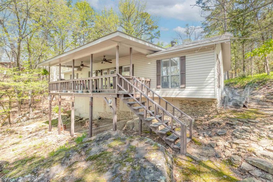 Lakefront Retreat in Tumbling Shoals – Private Paradise with Guest House Welcome to your dream lakefront home! Nestled at the end of a peaceful cul-de-sac, this unique property offers a rare blend of privacy, comfort,& access to Greers Ferry Lake.  The main home features 2 spacious bedrooms & 2.5 baths, a stunning open-concept design including a large great room & a gourmet kitchen perfect for entertaining. Natural light fills the living area, a covered deck provides the perfect place to unwind while enjoying the best sunsets on the lake & the soothing sound of a seasonal stream beside the home.  Just steps away, a charming 2-bedroom guest house offers extra space for visitors. There's even a dedicated office in the garage, great for working from home or creative pursuits.  With 120 feet of shoreline, you can swim, board your boat, or simply relax by the water. The property features both dramatic cliffs & accessible shoreline, blending beauty & convenience. Just across the lake from Dam Site Marina, you're never far from lake life.  Whether you're seeking a full-time home or weekend escape, this lakeside haven offers unforgettable views, flexible living space, & the amazing sunsets