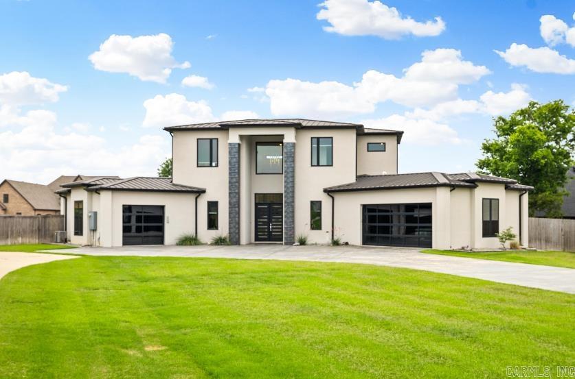 Experience luxury living in this modern coastal masterpiece located in an exclusive gated community. Situated on nearly an acre, this showstopper features a 100-year metal roof, grand 20-foot entry with tiled columns, and 2-story living room with marble-style floors, a stunning fireplace, and a glass wine cellar. The custom kitchen is a chef’s dream with Meile appliances, including built-in espresso machine, refrigerator, and ice maker. The expansive primary suite offers a cozy sitting area, spa-like bath with three vanities, and a massive walk-in closet. A guest suite is located on the main level and all bedrooms include en suite baths and walk-in closets. Enjoy a walk-in butler’s pantry with custom cabinetry, FEMA approved safe room, a covered balcony, a large covered back porch, and a fully fenced yard—perfect for a pool. The sleek 3-car garage with glass doors completes this exceptional home, ideally located near both Hot Springs and Little Rock. All furniture is available for purchase. Don't miss out on this special property!