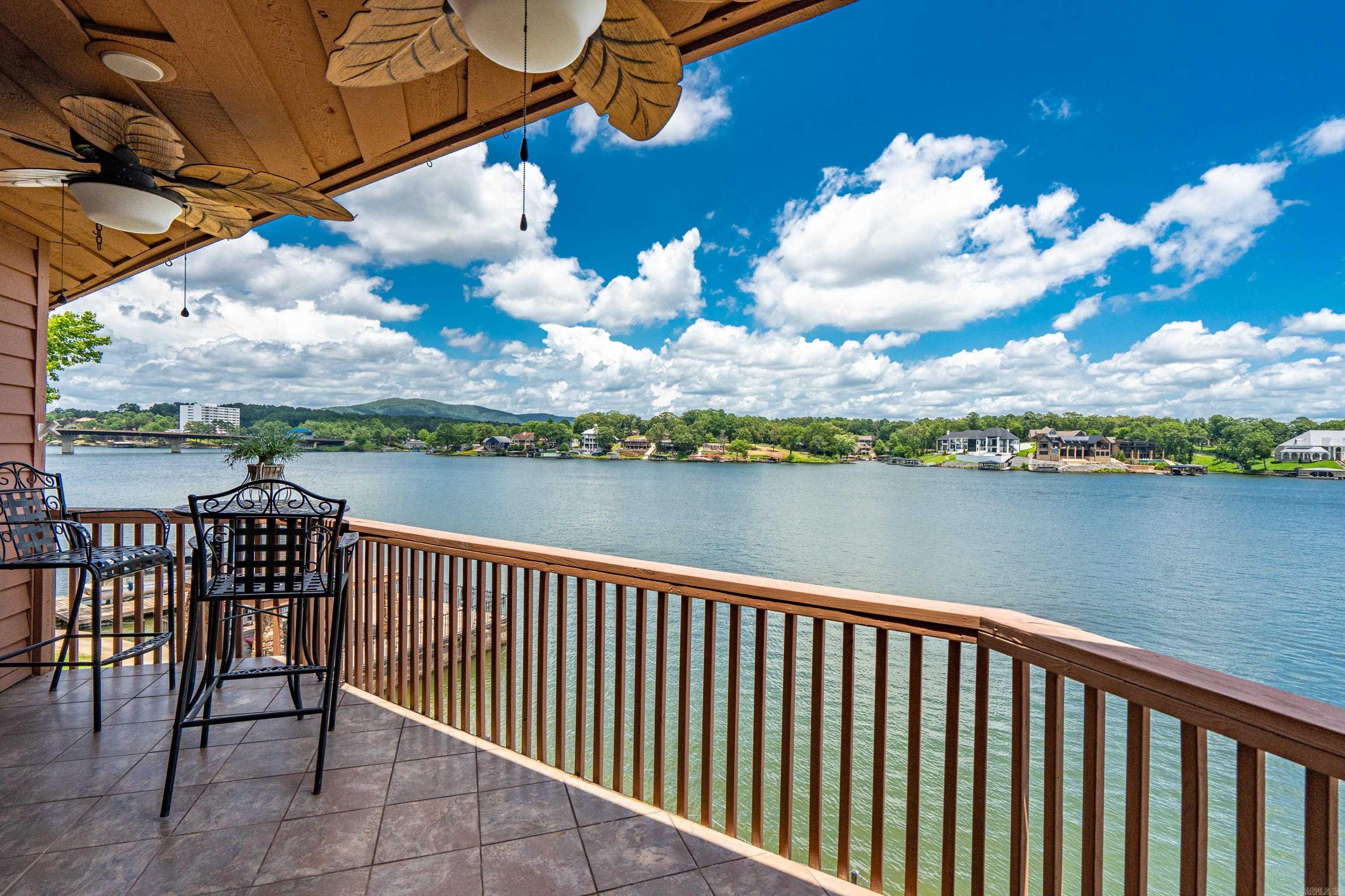 This is A LOVELY LAKE HAMILTON CONDO with a bird's eyeview of the Main Channel and right in the hub of all the FUN that Hot Springs offers! This home is selling beautifully furnished + includes a Covered Boat Dock with Lift! The location is convenient to everything in Hot Springs and also on Lake Hamilton! There are 2 Bedrooms, 2 Bathrooms, an efficient Kitchen with Stainless Steel appliances + adjoining Living Room/Dining Area with a lovely natural stone Fireplace. This gated development is private and secure for property owners and vacation rentals are not allowed.