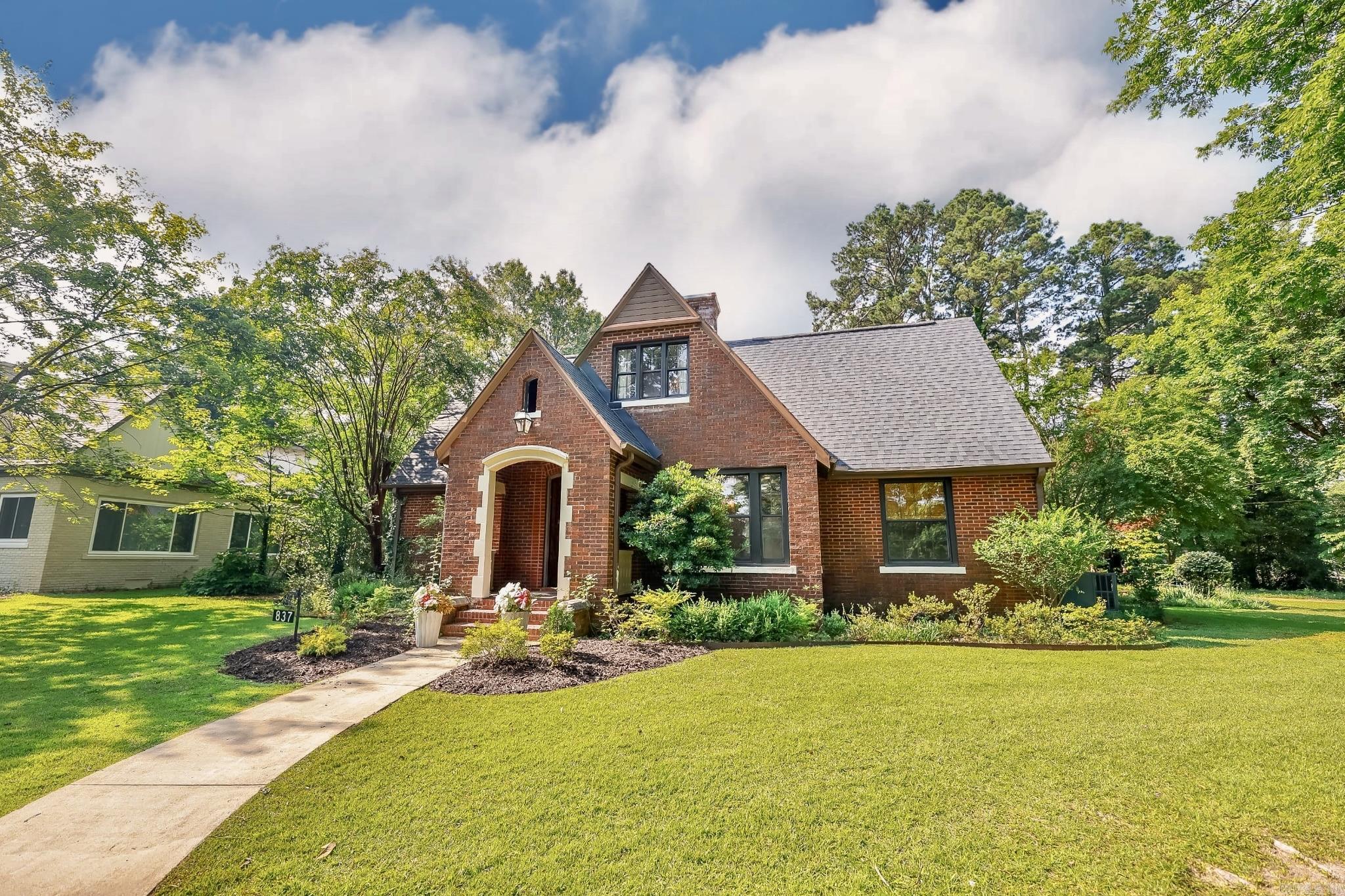 Listed on the National Register of Historic Places, the Laney House is a beautifully renovated English Tudor offering 4 bedrooms, 2.5 baths, and timeless charm with modern upgrades. Features include new electrical, plumbing, roof, custom kitchen with marble counters, built-in banquette, and refinished historic hardwood floors on both levels. The main floor includes a spacious primary suite and a study with floor-to-ceiling built-ins. Upstairs has three additional bedrooms, full bath, and ample storage. The detached 2-car garage includes a generous upstairs storage area. Outdoors, relax by the fire pit, let kids explore the large playhouse, or stroll through the beautifully landscaped yard with camellias, hydrangeas, azaleas, roses, pear and plum trees, and a fenced garden. A rare find in the heart of Camden! Property is agent owned.