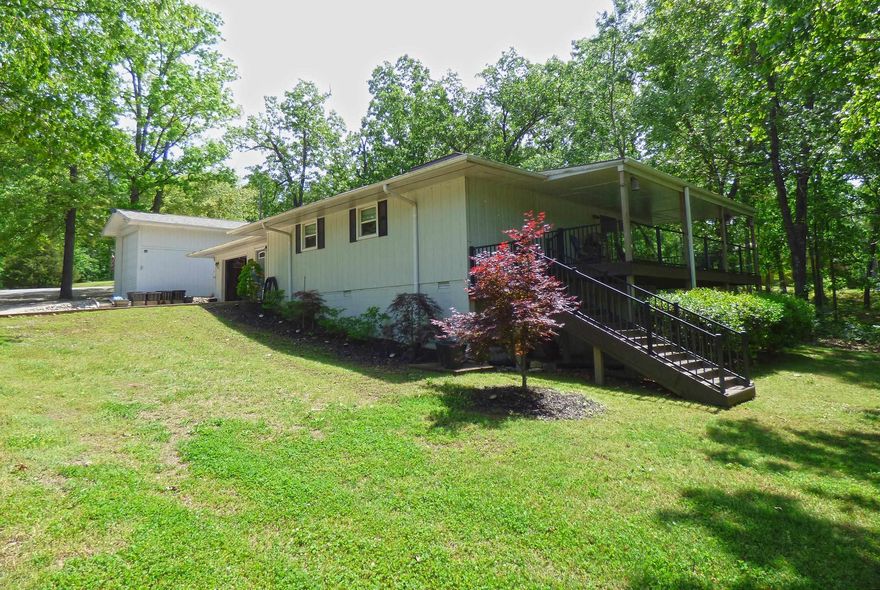 Built for comfort and ease of living, this home on Lake Navajo offers 1,344 sq ft of living space with 2 bedrooms, 1 3/4 baths, a great room floor plan with open living room, kitchen and dining, plus a 12x24 computer den. Features include granite counter tops,  2024 stainless steel kitchen appliances, pantry, central heat & air, native stone fireplace converted to gas logs, stand-up crawlspace with vapor barrier, concrete slab entry good for storage, fenced dog run, 2024 lifetime warranty architectural shingles, 2021 ultra low-maintenance wrap-around Trex deck with tempered glass panels for a full lake view, and the one-car attached garage and 14x32 detached RV garage with 30-amp electric and 12 ft door built in 2024. The yard gently slopes down to the lake shore with its fire pit seating area and 2022-built fishing dock. Our community offers seasonal farmer's market, festivals and music events, seven lakes and marina, two 18-hole golf courses with no tee time, walking/biking trails & parks,  RV & tent campground, community centers with pools, fitness center, and pickle ball courts. This lake home has style and character and has been beautifully maintained with you in mind.