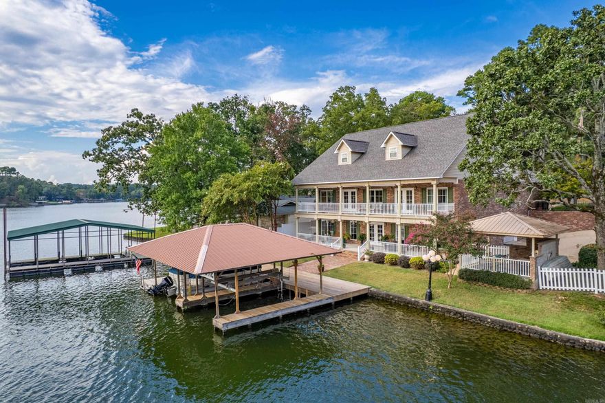 Welcome to 431 Lockhaven Point—an exceptional lakefront home on Lake Hamilton offering approx. 4,500 SF, 5 bedrooms, and a flexible office space. Enjoy panoramic water views from the main living area and chef’s kitchen featuring granite counters, custom cabinetry, a butler’s pantry, and a kitchen island with butcher block that does not convey. A formal dining room and second kitchen downstairs with private access to the walk-out basement make hosting easy. (Note: downstairs refrigerator does not convey.) The spa-inspired primary suite includes a jetted tub, oversized shower, and large walk-in closet. A finished attic and large workshop on the main level with garage access add versatility. Outdoor living includes upper and lower decks, a covered outdoor kitchen, and a two-stall boat dock. With maintenance-free flooring, a double garage, and a peaceful setting near the water, this home blends comfort, privacy, and lakefront luxury. Contact the listing agent for a private showing.