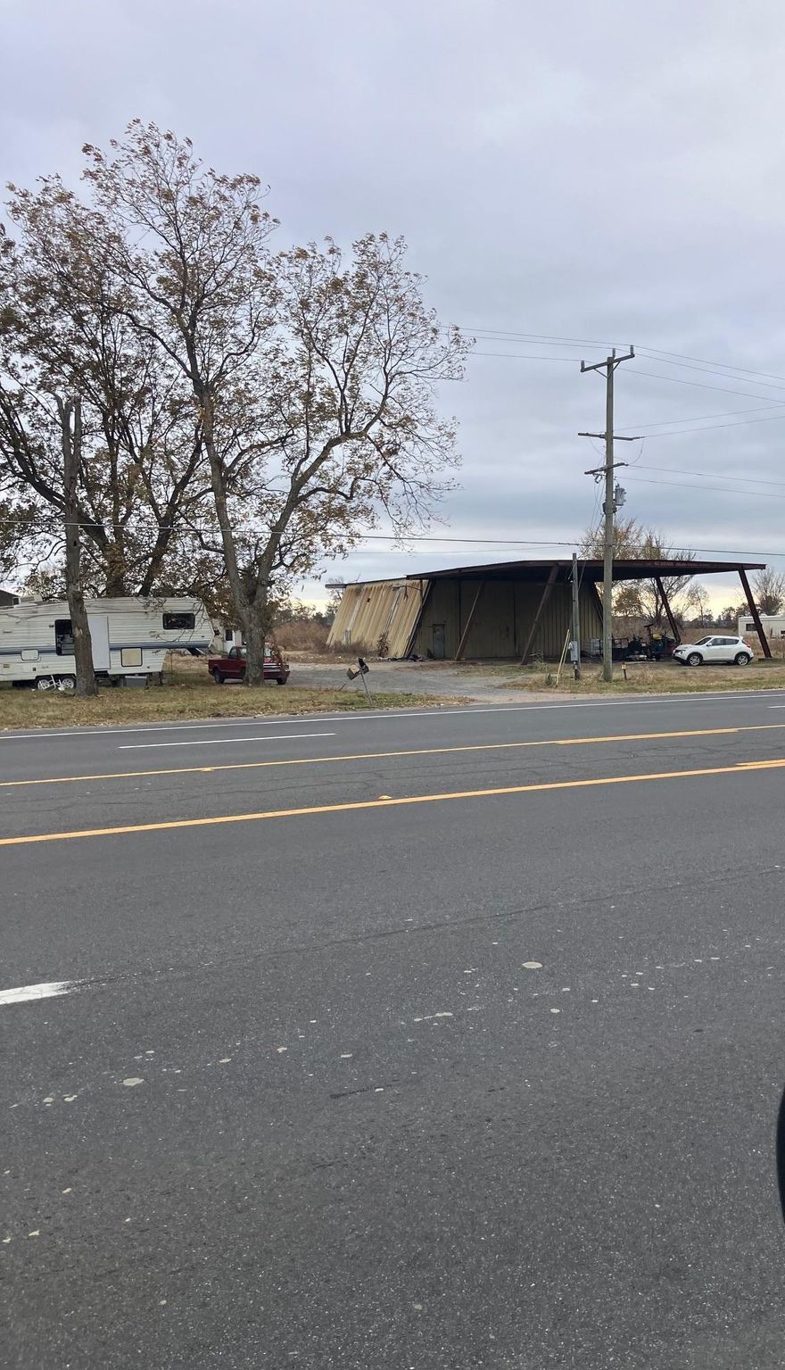 This versatile commercial property, located at 1943 Hwy 18 in Blytheville, Arkansas, presents an outstanding opportunity for commercial operations, particularly those requiring significant covered work and storage space. The heart of the property is a robust metal shop featuring 2,500 sq ft of enclosed space boasting 14-foot sidewalls, ideal for accommodating large equipment, specialized manufacturing, or extensive fabrication projects. Complementing the main building is an additional 1,500 sq ft open shed, providing flexible, covered space for material storage, vehicle parking, or outdoor work that requires shelter from the elements. Situated on 2.4 acres more or less (m/l), the site offers ample room for expansion, maneuvering commercial vehicles, and securing a laydown yard. In addition to the primary commercial structures, the property includes a 952 sq ft old brick house. While this residential component may offer potential for repair and repurposing—such as an on-site office, caretaker's residence, or rental income source—prospective buyers should assume this feature is in uncertain condition. The entire property is being offered on an "as-is, where-is" basis.