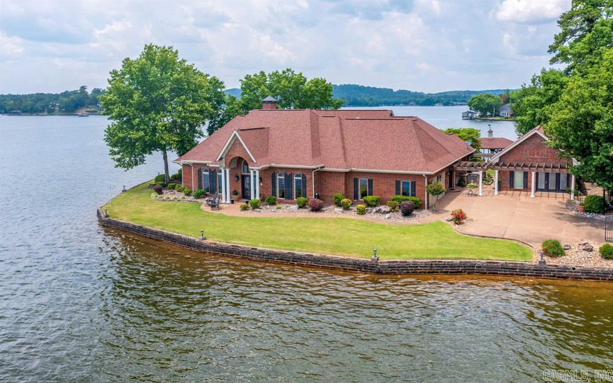 Breathtaking PREMIUM Lake Balboa Waterfront home! Gated & on the Point of a Peninsula with nearly 400 feet of surrounding Seawall! Enjoy Views of the Lake from every room, many overlooking the pool. The property includes the main house which has 3 bedrooms 2 1/2 baths, + a Guest House with 2 rooms and a Jack & Jill bath (currently used as bedrooms 4 and 5). Entertain beneath the Pergola, BBQ next to your Pool, get cozy in front of the Outdoor Brick Fireplace, or enjoy the sunsets on the patio area at the point.  The Sitting Room looks onto the manicured Grounds and Covered Boat Dock with Lift! The Granite Gourmet Kitchen boasts Two Islands, a Sub Zero Fridge, a six burner (+ griddle) Thermador Professional Gas Range with Pot Filler, and additional Thermador and KitchenAid stainless steel appliances! A rich wood Dry Bar is convenient to the gathering areas, including the Formal Dining Room with beautiful Chandelier! The Central, Open-Concept Floor Plan with Cathedral Wood Ceiling is accented by a Floor-to-Ceiling Ledgestone Pillar and Gas Fireplace! The Primary Suite opens to the adjacent Sitting Room & 5 Piece Ensuite with Elevated Tub and Walk-In Closet. This is truly a RARE FIND!