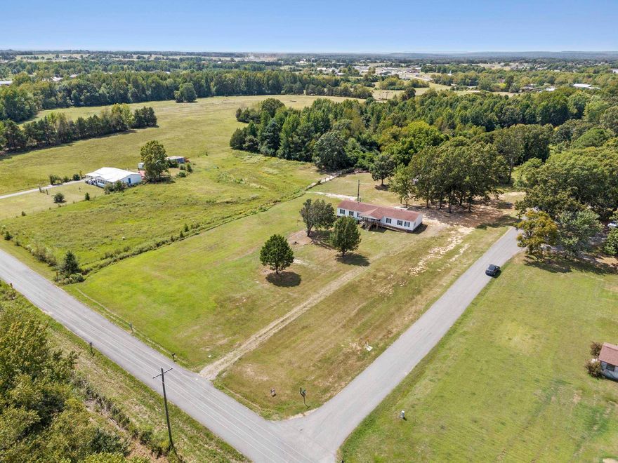 Home and 2-1/2 Acres with a small barn and room for horses and a garden.  This has a huge yard on a corner lot and convenient to town. The master bedroom has an attached office or workout area and a large ensuite bathroom and closet. Both front and back porches are covered with a wheelchair ramp to the front porch.  Its underpinned with brick on a permanent foundation.