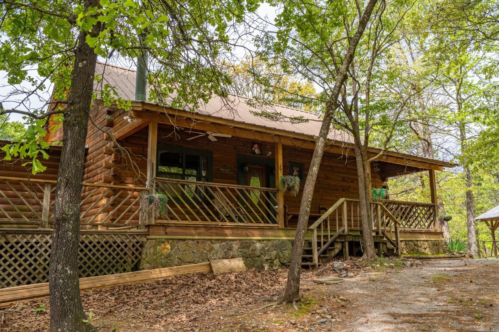 Log Cabin livin' with a killer view! Own your own little piece of paradise in the mountains. Located just 2 miles from the round about outside the Village gates. From the moment you walk thru the front door you are transported to a hunting lodge with warm wood tones, natural lighting and breathtaking views of the surrounding mountains. With 3 bedrooms and 3 full baths in the main home you'll have plenty of room for everyone in the family. The large open floor plan makes entertaining a breeze or move your party downstairs to the huge bonus room. The massive back deck overlooks the 5+ acres and has a walkway to the garage apartment with a bedroom and full bath for your overnight company. So gather your family and guests for a night of star gazing on the back deck! Welcome Home!
