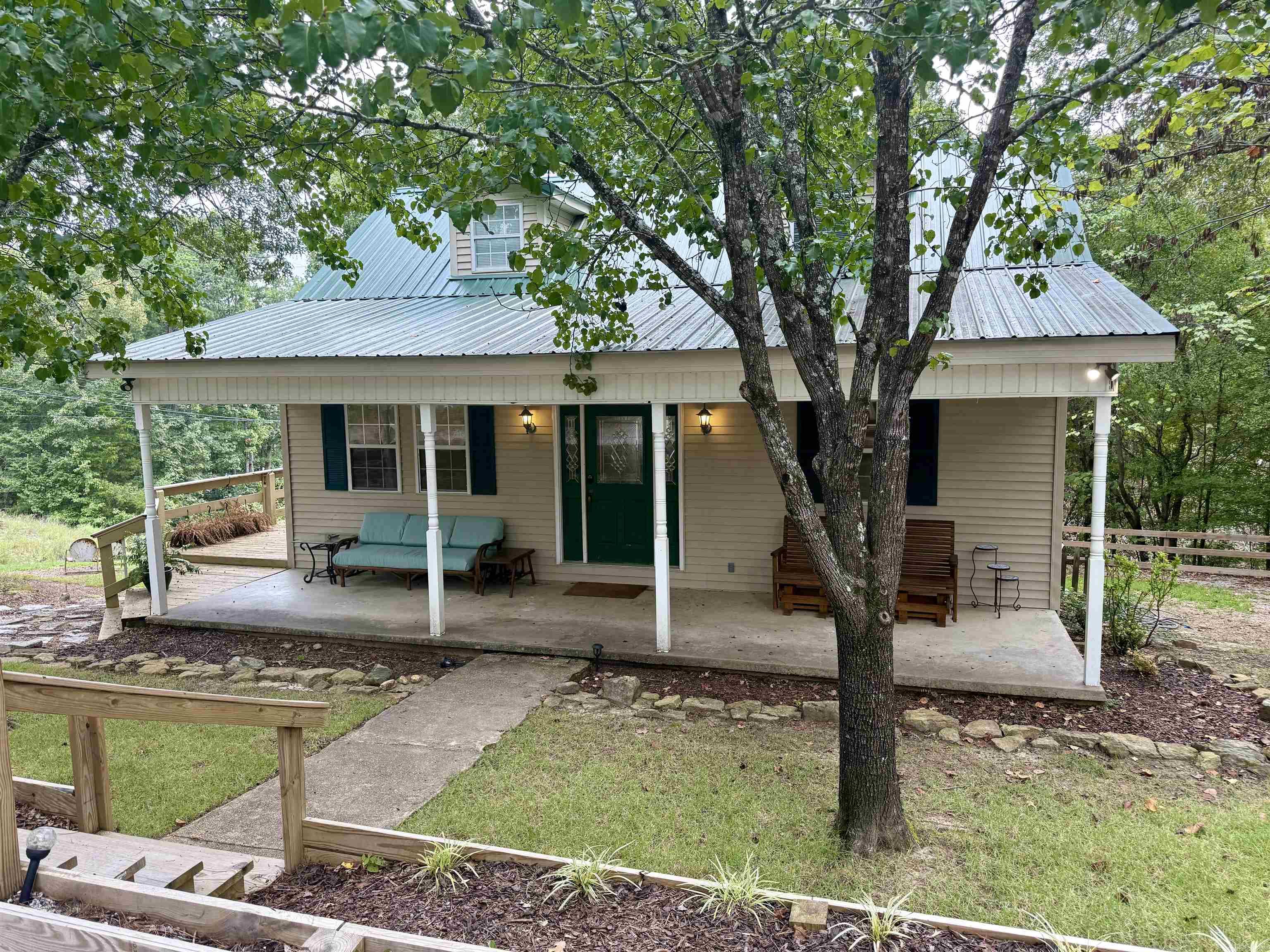 Looking for a lake getaway? This charming 3-bedroom, 1.5-bath home sits on a 1-acre lot just steps from Greers Ferry Lake, offering peaceful winter water views and easy access to a quiet boat launch about 2 miles away on Ramp Lane. The spacious wraparound deck and cozy front porch provide plenty of outdoor living space, while the newly landscaped yard includes extra parking pads for your boat and trailer. The main floor features a primary bedroom with a full bath, and two guest rooms upstairs share a half bath. With an 9-year-old metal roof, luxury vinyl flooring, and a new HVAC system, this well-maintained 2-story home is currently a successful vacation rental, making it a fantastic opportunity for a vacation rental or your own private retreat.
