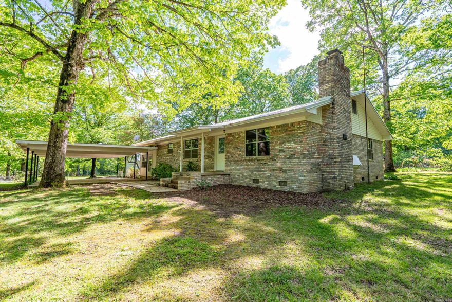 Looking for a serene, private location surrounded by woods and wildlife? Share your morning coffee with the deer that graze nearby. This 1914 sq. ft. 3 bedroom, 2 bath ranch style brick home is for you. Wood paneled walls throughout the home add to the cozy, country feel. The home has central A/C and heat, but also has a fireplace insert and a propane wall heater installed to make sure you stay warm in the winter. Home has city water but also has a working well. Located on 10.5 gated, fenced acres of timber and pasture land in Fountain Lake school district. The yard and garden area are filled with figs, grapes, fruit trees, and multiple flowers and rose, azalea, and lilac bushes. Imagine the seasonal floral and fruit surprises you will get to experience and share. The established garden area is 104 ftX86 ft. There is a catfish and brim stocked pond a few yards from the home. A cute/functional gated red barn could be used to house your favorite animal or for additional storage. Separate storage outbuilding w/woodshed located on the property. Detached workshop has its own 1/2 bath and carport. Detached workshop could be also used as a garage or possibly converted to a guest cottage.