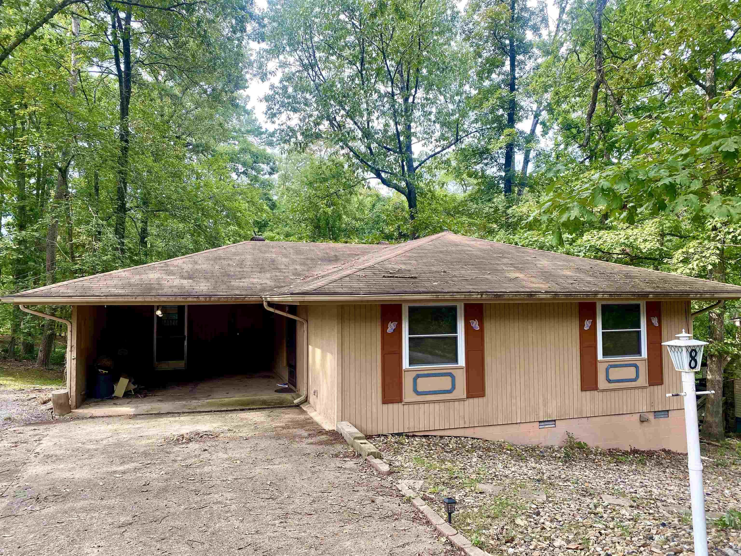 An Investor's Dream! Great one-level home in a cozy neighborhood close to Lake Cortez with 2 bedrooms and 2 baths. It ALSO has an ADDITIONAL LARGE ROOM not included in the square footage, and it adds an extra 344 sf to the home (see the diagram in photos.) There's a convenient small WORKSHOP with a sink and toilet right off the carport, plus a deck on the back facing lush private woods. You'll appreciate the flat driveway, and that the roof has already been inspected- and the shingles are in great shape! This home needs some TLC and will be sold "AS IS". Hot Springs Village offers plenty of nearby acitivites to this home...Pickleball Courts, a community outdoor pool, the DeSoto Golf Course, as well as Lake DeSoto and Lake Cortez for fishing and boating. All offers considered, see this one TODAY!