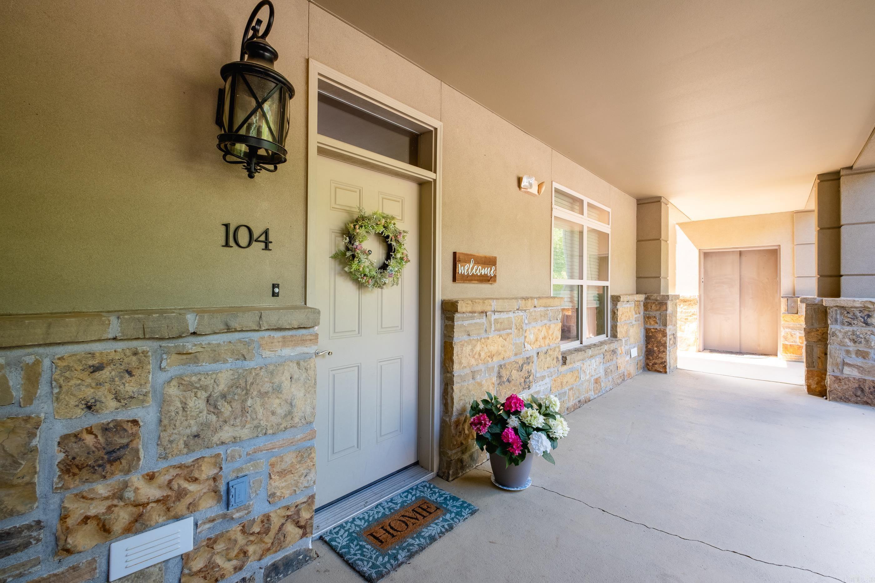 The premier unit of Vallon on the main floor with windows on the front back and side that allow plenty of natural light! Site finished hardwood floors throughout the home along with carpet in the bedrooms and tile in the baths. The living, dining and kitchen are very large and open to each other. The living room has a gas logs fireplace and doors that lead out to the covered patio. The kitchen has lots of cabinet space along with stainless steel appliances and granite countertops with a breakfast bar. Both bedrooms are very good sizes with the primary having lots of windows. The primary bath has a separate tub and shower, two vanities and a large walk in closet. 9 Foot ceiling throughout. The patio looks onto grounds that contain a walking path, putting green and pool area with a hot tub and two cabanas - one having a fireplace and the other a kitchen area. A lovely garden is also located on the premises.
