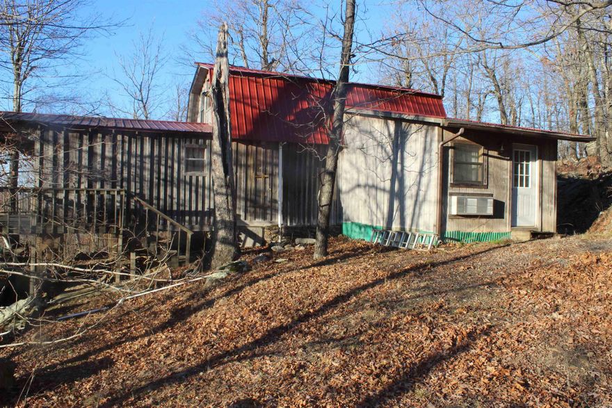 CABIN WITH GREAT VIEWS!!! A 1128 sq. ft. cabin sitting on 20 acres of recreational, timberland, hunting land. This would make a great weekend getaway or a forever home. Cabin features a rustic style interior with a 1 bed and 1 full bath, living room, separate dining room, and a galley style kitchen on the main level. The upstairs loft area is used as a second bedroom and also has a full bath with a soaker tub.  Outside is a rustic style with a covered side porch and covered front porch where you can enjoy some great views and some of the areas best sunsets. Clearing of a few trees would offer the view year round. Cabin has a whole house generator on place. A garage/shop for storage is also on the property. For the avid hunter an abundance of wildlife are in the area consisting of whitetail deer, turkey, bear, and numerous small game animals. Explore the property and discover the numerous rock features on the property. Nearby is the Buffalo National River where you can enjoy kayaking, fishing, hiking, and numerous other outdoor activities. Beds, dining table and chairs, living room furniture, washer, dryer convey at no monetary value. Don't miss out on this one!!!!