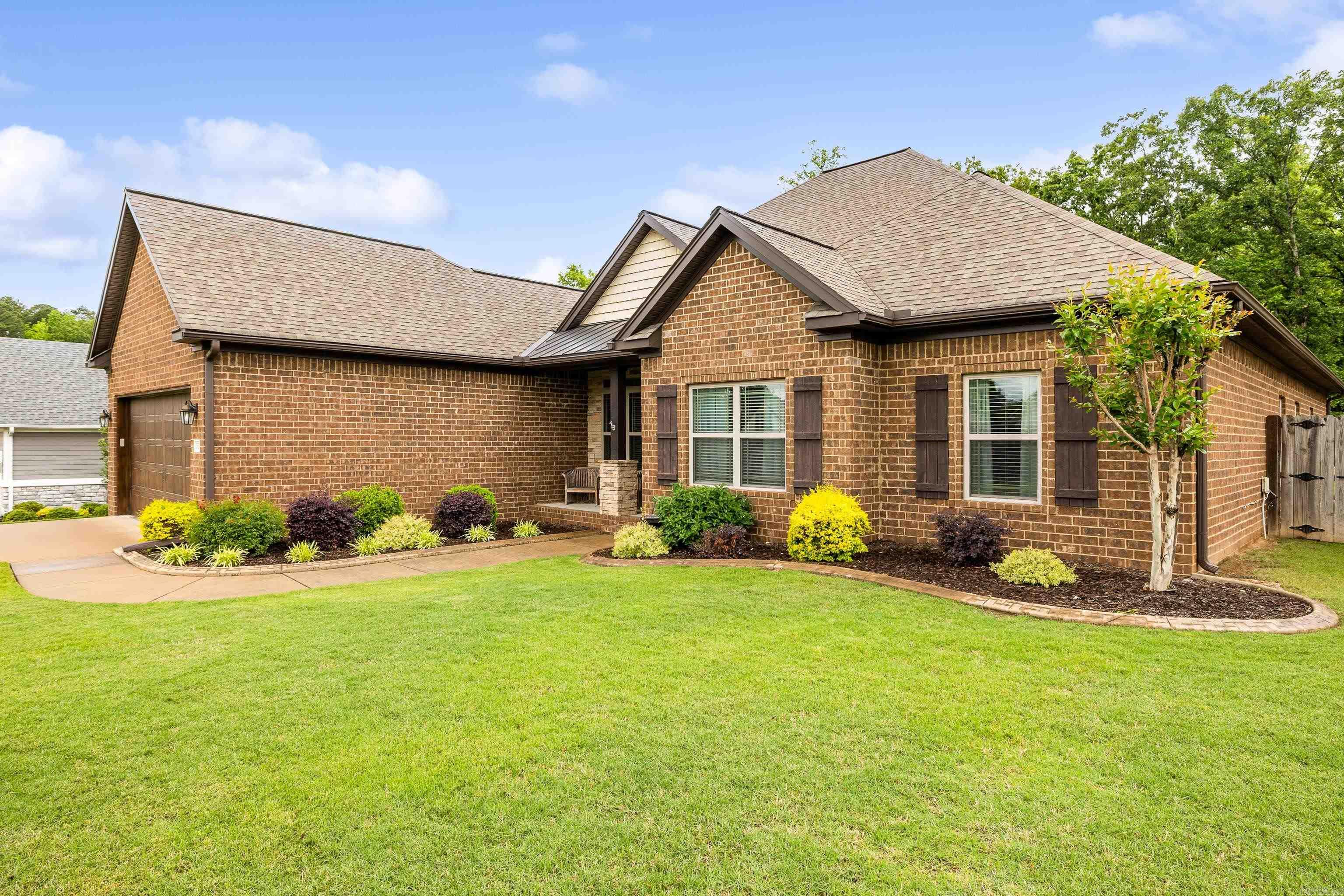 PRISTINE HOME IN THE HIGHLY SOUGHT AFTER HARPER'S LANDING NEIGHBORHOOD OF BRYANT! This stunning home features hardwood floors, soaring ceilings, and beautiful custom trim throughout. The chefās kitchen includes granite countertops, an island with gas range, spacious walk-in pantry, and wraparound bar seating that opens to a cozy hearth room with gas fireplace. A spacious living room and formal dining area make entertaining easy. The primary suite offers two vanities, two closets, and a custom tile shower, while the three guest bedrooms all include massive walk-in closets. Large laundry room with storage and mud area with bench and hooks. Situated on a large lot backing to private woods, the backyard features a covered porch, stained concrete patio perfect for a firepit, and a custom-built storage building on slab. Quiet, one-way-in, one-way-out neighborhood in the heart of Bryantādonāt miss this one!