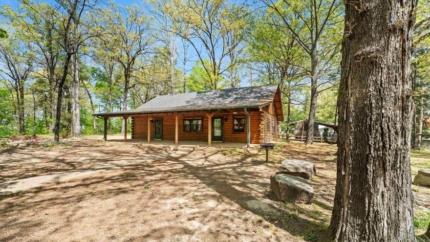 This stunning log cabin, located just moments from Yarborough Landing in the heart of Millwood Lake, offers partial views of the lake on one side and the golf course on the other. Whether you're seeking a peaceful vacation retreat, a serene country home, or an investment property for short-term rentals, this home is a perfect fit. Millwood Lake is known for it's renowned fishing and picturesque surroundings. The cabin itself is nestled in between the lake and Millwood Golf Resort and near the state park. Enjoy outdoor living at its finest with a spacious porch, a cozy fire pit area, and a BBQ space, all surrounded by trees. Additional features include an outbuilding for extra storage and ample parking for your boat. One of the bedrooms offers its own private entrance from the patio. This well-maintained home is ready for you to move in and start enjoying the tranquil lifestyle Millwood Lake has to offer.
