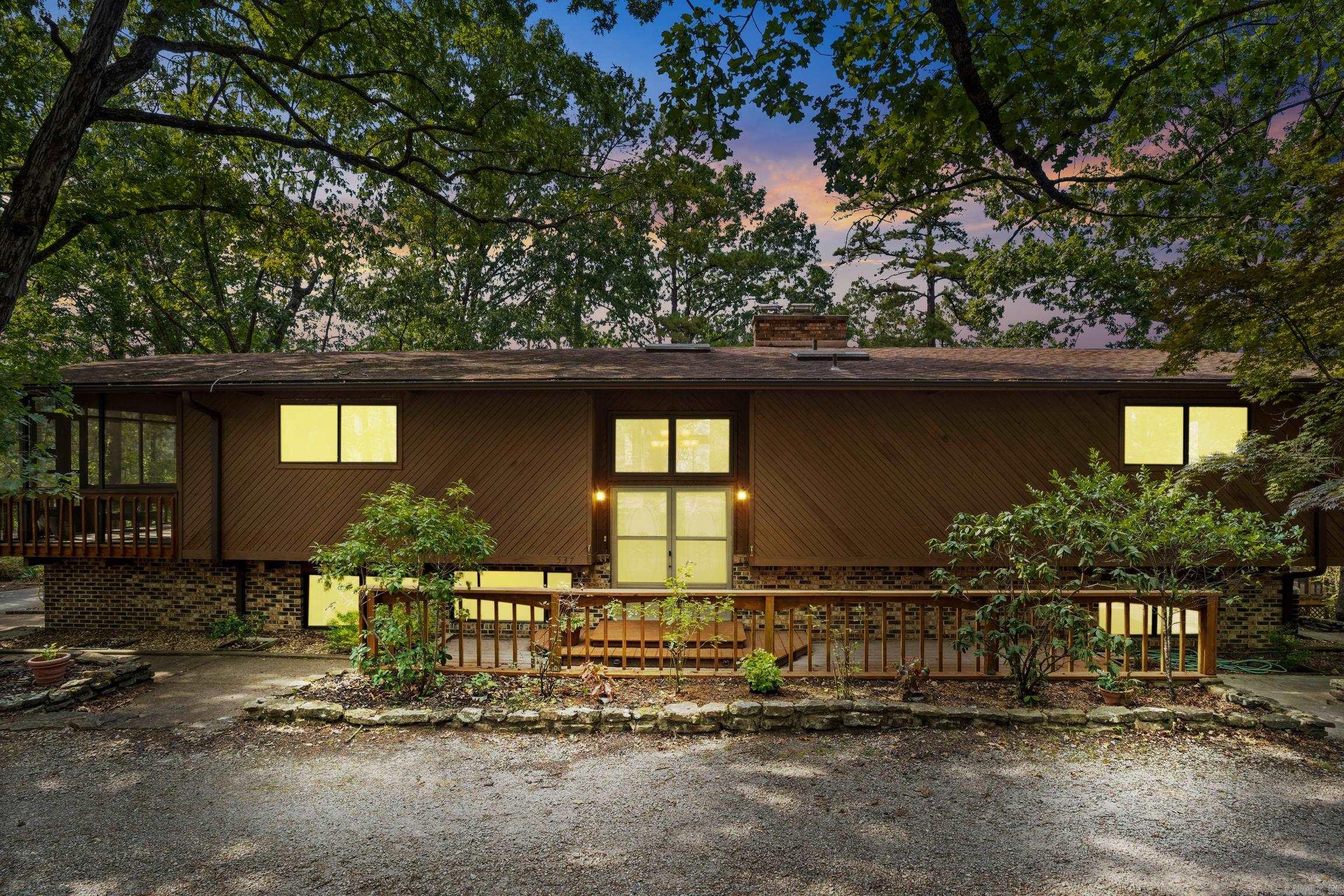 Discover this mid-century modern retreat on over 2 acres, just minutes from the White River. Featuring 3 bedrooms and 3 full baths, this 3,904 sq ft split-level home boasts vaulted wood ceilings, 2 woodburning fireplaces and expansive space for entertaining. The large kitchen features double ovens, breakfast bar and island. Enjoy your private woods with over 2,200 sq ft of decking or relax in a screened-in porch. The 600+ sq ft primary suite includes 3 closets, private entrance, and en-suite bath with jetted tub. Swim in the screened-in, roofed and heated above-ground pool. A detached 2-car garage offers additional bonus storage, while the 423 sq ft heated/cooled workshop is ideal for projects. With thoughtful upgrades like a central vac system and real wood floors, this property blends luxury and functionality. Perfect for those seeking a stylish home with privacy, recreation, and room to entertain, all in a prime location near world-class fishing and the natural beauty of Norfork.