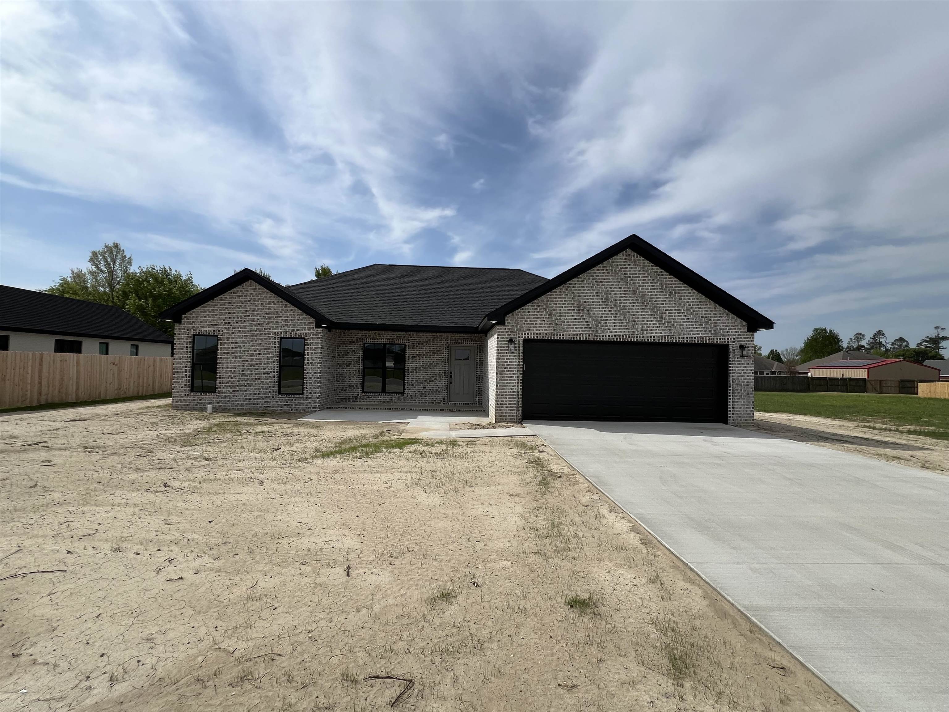 Lovely new construction brick home with 3 bedrooms, 2 baths. A large patio and front porch are welcoming additions to the entry, providing extra space for decorating and enjoying the neighborhood. The living and kitchen are open to each other. The kitchen has a nice pantry, gorgeous island and the cabinetry is topped with black granite throughout the home. Black on white windows and LVT flooring. The garage entry is roomy and has a large drop zone and access to the laundry room. The Primary Suite is located on this side of the home and offers a well designed closet, nice tiled shower, double vanities and water closet. On the opposite side of the home are two bedrooms, two linen closets and bathroom. Access to the back porch and back yard can be found just off the kitchen.