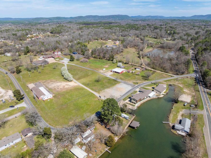 This remarkable 8.13-acre property offers a unique combination of residential, recreational, and development potential, with 361 feet of lakefront and a commercial launch ramp that provides incredible convenience for water enthusiasts or commercial possibilities. The expansive 4,641 sq ft home at 133 Treasure Isle provides spacious living and outdoor areas for family and guests. The property also includes three additional storage or shop buildings, ideal for boat/RV storage or workshop space. Adjacent to this, 130 Treasure Isle offers 3.2 acres with a 2,860 sq ft garden home, a large storage building, plus other outbuildings. At 150 Treasure Isle, the 4.26 acres features a 3,420 sq ft auction barn with eight 12x30 storage units, one outside storage unit, and a small, manufactured building currently serving as an office. With Highway 270 visibility, Lake Hamilton frontage, and Treasure Isle Road frontage, the property offers significant visibility and access, making it a prime candidate for residential, multifamily, or commercial development. Whether you're seeking a private retreat or a development opportunity, the possibilities are endless.