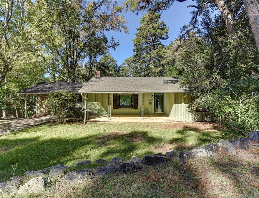 Charming Home in Historic Park Avenue District  Located in the desirable Historic Park Avenue area of downtown Hot Springs, this ranch-style home sits across from National Park land and is within walking distance of Bathhouse Row, West Mountain, and scenic hiking and biking trails.  It offers a spacious living room with picture windows, hardwood floors, and a brick fireplace. The roof was replaced in October 2025. The enclosed garage makes a great option for a third bedroom or family room and features a rock wall and large window.  Enjoy the covered back porch overlooking a large, private backyard with fire pit and stone walkways. A great home to enjoy as-is or update for investment.