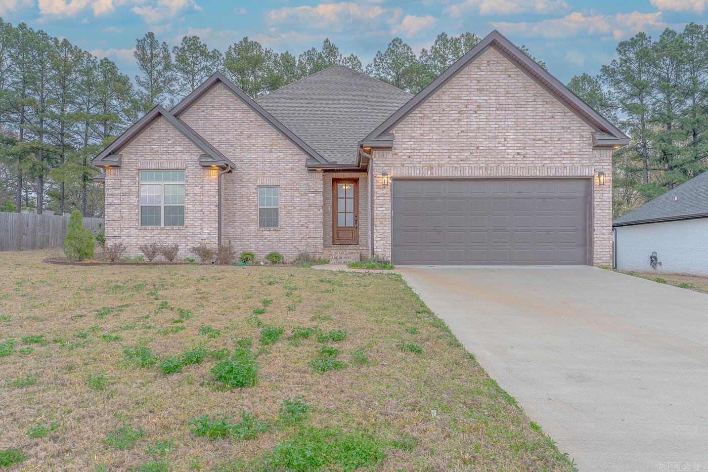 Welcome to Market 218 Gulley Drive within the Gatlin Crossing of Whispering Hills Subdivision in Brookland, Arkansas within the Brookland School District. Situated on a .32 +/- acre lot with tree lined views is a 2022 built all brick beauty topped with architectural shingles, and accented by guttering, covered back porch, patio, 2 car garage, and inviting landscaping. The interior features 2,150 sf of well laid out living space over a split floor plan that contains: an open concept living/kitchen/dining area that holds a grand living room with soaring ceiling, stained wood beams, floor to ceiling cozy gas fireplace, eat-in kitchen with stainless steel appliances, pantry, tiled backsplash, quartz topped island with bar seating, and access to the backyard patio. The Master wing is sure to impress with a large bedroom with tray ceiling and en-suite featuring walk-in closet, walk-in tiled shower, soaker tub, and separate vanities. The spare wing holds three generous sized bedrooms with ample closet space and a guest bathroom with shower/tub combo. Conveniently located near favorite local amenities with easy access to Highway 49 North. Call today to tour and make this house your home.