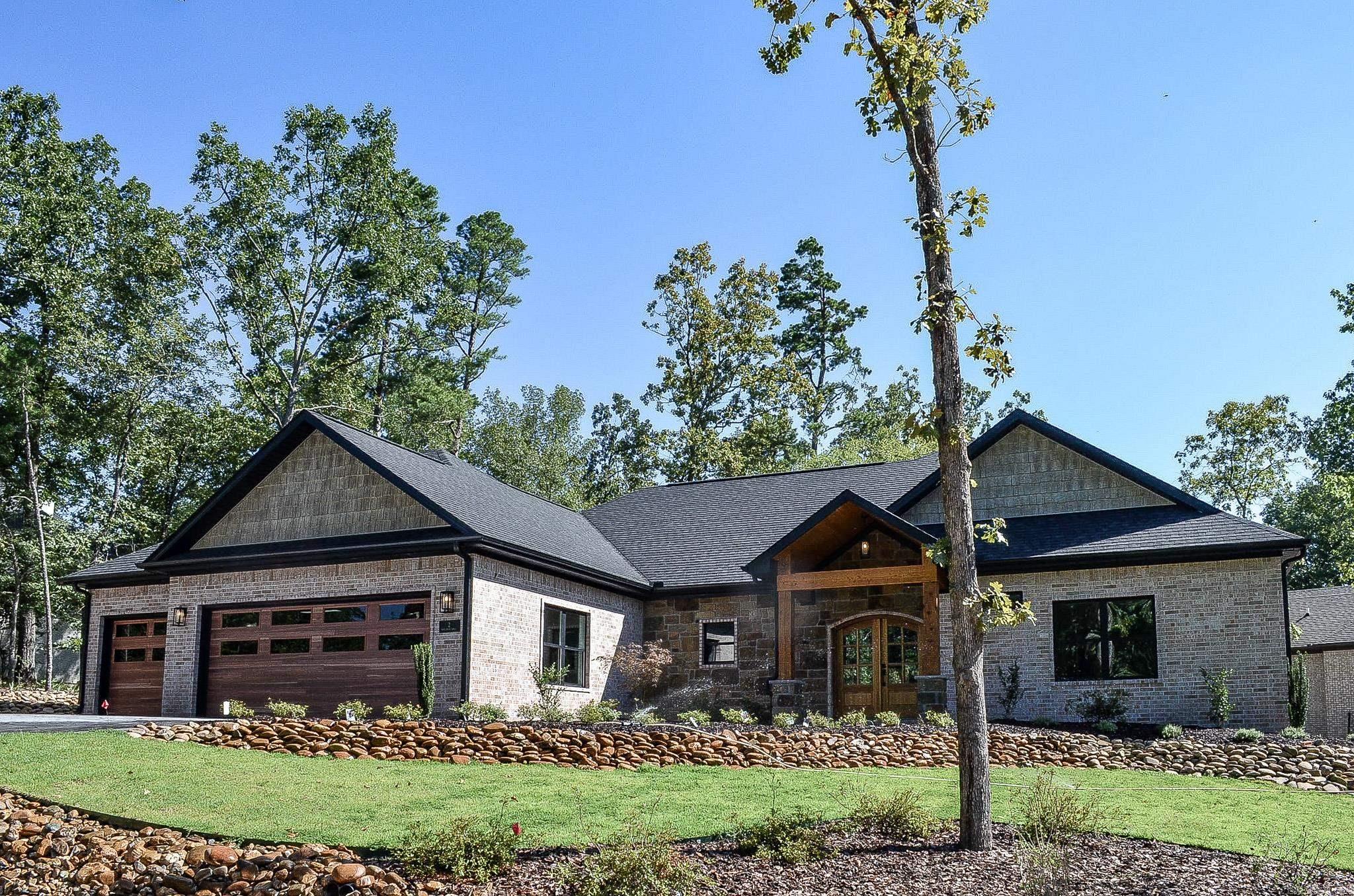 Beautiful 4-bedroom, 3.5-bath new construction on an oversized corner lot in the desirable Resplandor neighborhood! Exterior includes white-wash brick, black architectural shingles, cedar-tone shake gables, V-groove pine ceilings, and natural rock accents. Stamped concrete porches front and back. The screened back porch features a dual gas/wood-burning fireplace, 32" built-in grill, outdoor sink, and fan—ideal for entertaining. Inside, enjoy a 10-foot quartz island (Taj Mahal), perimeter quartz counters, subway tile backsplash, black appliances, and black composite farmhouse sink. Living area features built-in TV wall, linear electric fireplace, and tray ceilings with crown and LED lighting. The primary suite includes a freestanding tub, tiled walk-around shower with pebble accents and dual heads, and custom closet. Guest rooms offer en-suite options and tiled composite tub/shower. Extras: engineered oak floors, tile in wet areas, walk-in pantry, laundry with quartz sink, zoysia yard with sprinklers, and rock planters with drip system. Agents review showing and agent remarks. Additional photos soon.