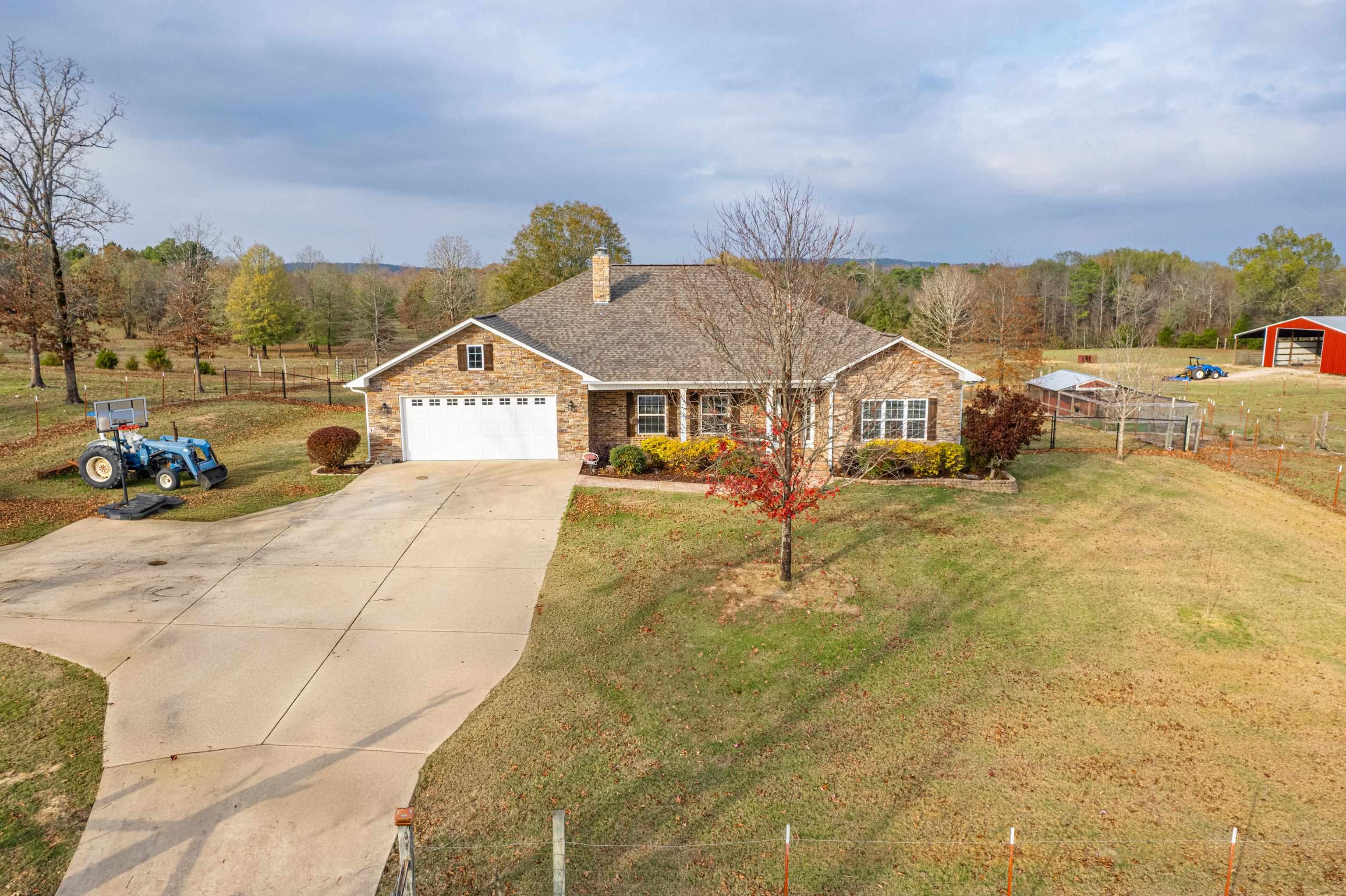 33.5 acres and Lake Hamilton School District! This custom built 2580 sq. ft. brick home has crown molding throughout, wood burning fireplace, an office/den (possible 4th bedroom), utility room with sink, large barn, tall carport, two ponds, chicken coop, dog pen, garden beds and is generator ready. Primary bedroom has vaulted ceiling, large walk-in closet, en-suite bathroom with jacuzzi tub, walk-in shower and electrical outlets built into bathroom drawers. Large guest bedrooms give everyone enough personal space. Open concept kitchen, dining and living room. Appliances stay including a new 2024 refrigerator. Attached two car garage with workshop area. Energy efficient windows, extra insulation in the attic and interior walls for efficiency and sound. Exterior walls are load bearing, so interior walls can be moved if desired. All electric and fiber at the street. Make your appointment today!