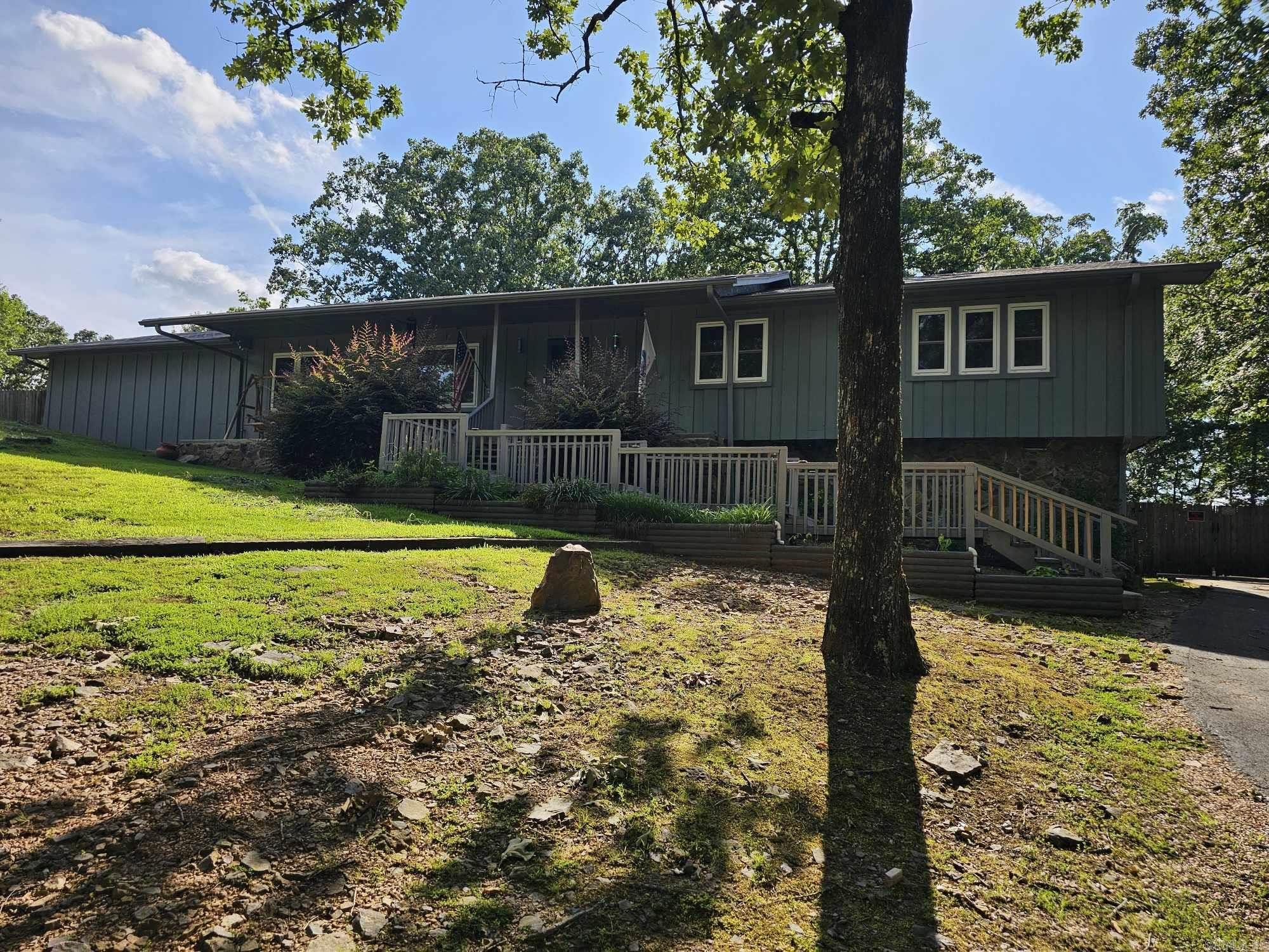 Nature loverās dreamāright inside the city limits! This beautiful, private home is surrounded by mature trees, offering a peaceful retreat without sacrificing convenience. Enjoy your mornings on the charming covered front porch, perfect for rocking chairs and relaxing. Step inside to find multiple living spaces, including a formal living room, a spacious great room, and a dedicated dining roomāperfect for both entertaining and everyday living. The updated kitchen features modern appliances and a breakfast bar that opens to the great room, creating an open, inviting feel. All bedrooms are generously sized. The primary suite includes a walk-in shower, while the guest bath is equipped with a walk-in tub for added comfort and accessibility. Out back, youāll love the large deck with a ramp for easy access, ideal for relaxing or hosting gatherings. A circular driveway wraps around to the rear of the home, leading directly to the ramp and lower level. Donāt miss the expansive bonus room with French doors opening to the patioāgreat for a game room, home gym, or creative studio. Plus, thereās a partially finished basement with a garage door, offering extra storage or workshop potential.