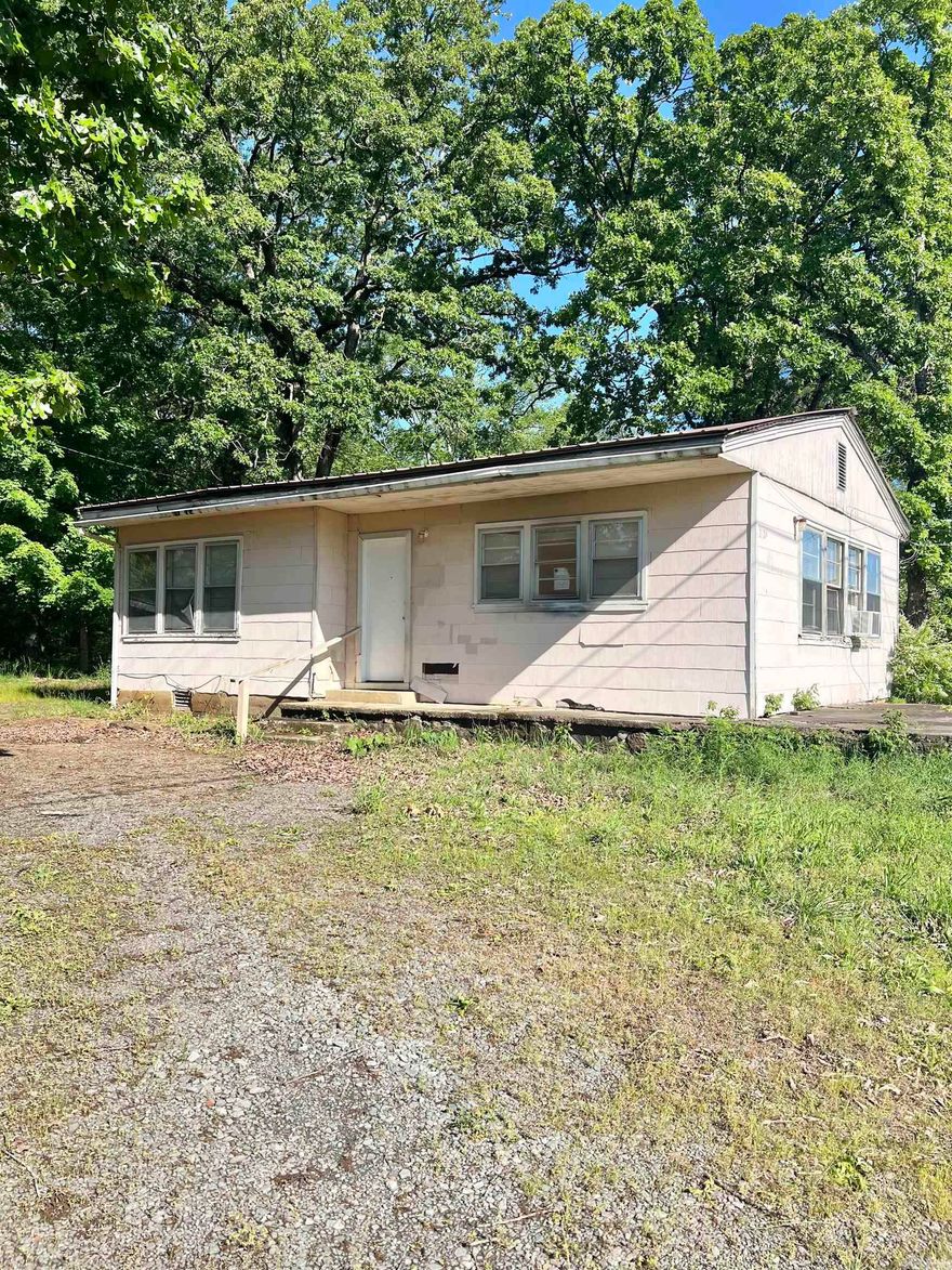 Charming 2-bedroom, 1-bath home situated on 3.01 acres right on Highway 65—offering both visibility and versatility for residential or commercial use. This property has already seen some updates and is partially remodeled, providing a great head start for a buyer with vision. With just a bit more work, it could easily be transformed into a comfortable home or a unique business location. The large screened-in porch adds valuable outdoor living space, and the expansive lot offers plenty of room to expand, garden, or develop further. A fantastic opportunity with endless potential! *See agent remarks
