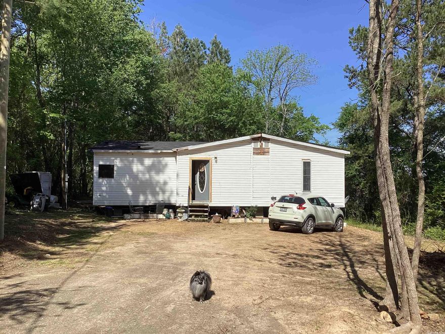 Lots of possibilities with this Rural property.  Home is a spacious Triple Wide mobile home.  Country setting but with City Water and Sewer.  Needs some rehab to meet its full potential.  Being sold "AS IS WHERE IS".