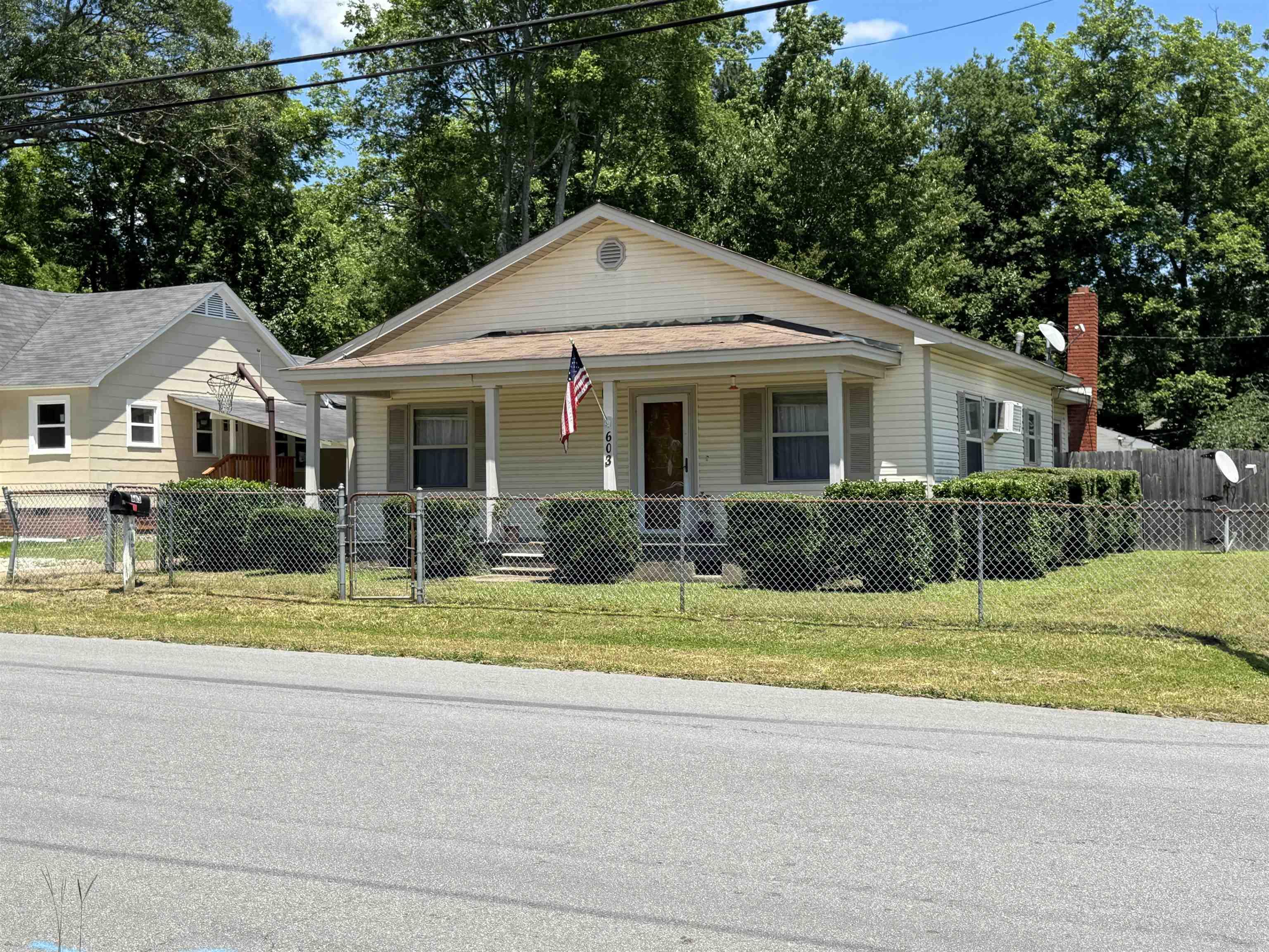 Step into timeless charm with this well-maintained 1950s home featuring modern updates and classic appeal. Situated on a spacious corner lot, this 3-bedroom home offers insulated windows, energy-efficient vinyl siding, and a large inviting front porch perfect for mooring coffee or evening relaxing. Enjoy the privacy of a fully fenced backyard-ideal or pets, children or entertaining-plus a handy outbuilding for extra storage or workshop space. Inside, you'll find cozy living areas and plenty of natural light, blending the character of an older home with the convenience of thoughtful upgrades. Don't miss this rare fined with curb appeal and prime location. There is a brick area in Dining room for a wood burning stove. Only 20 minutes to Hot Springs National Park and Oaklawn.