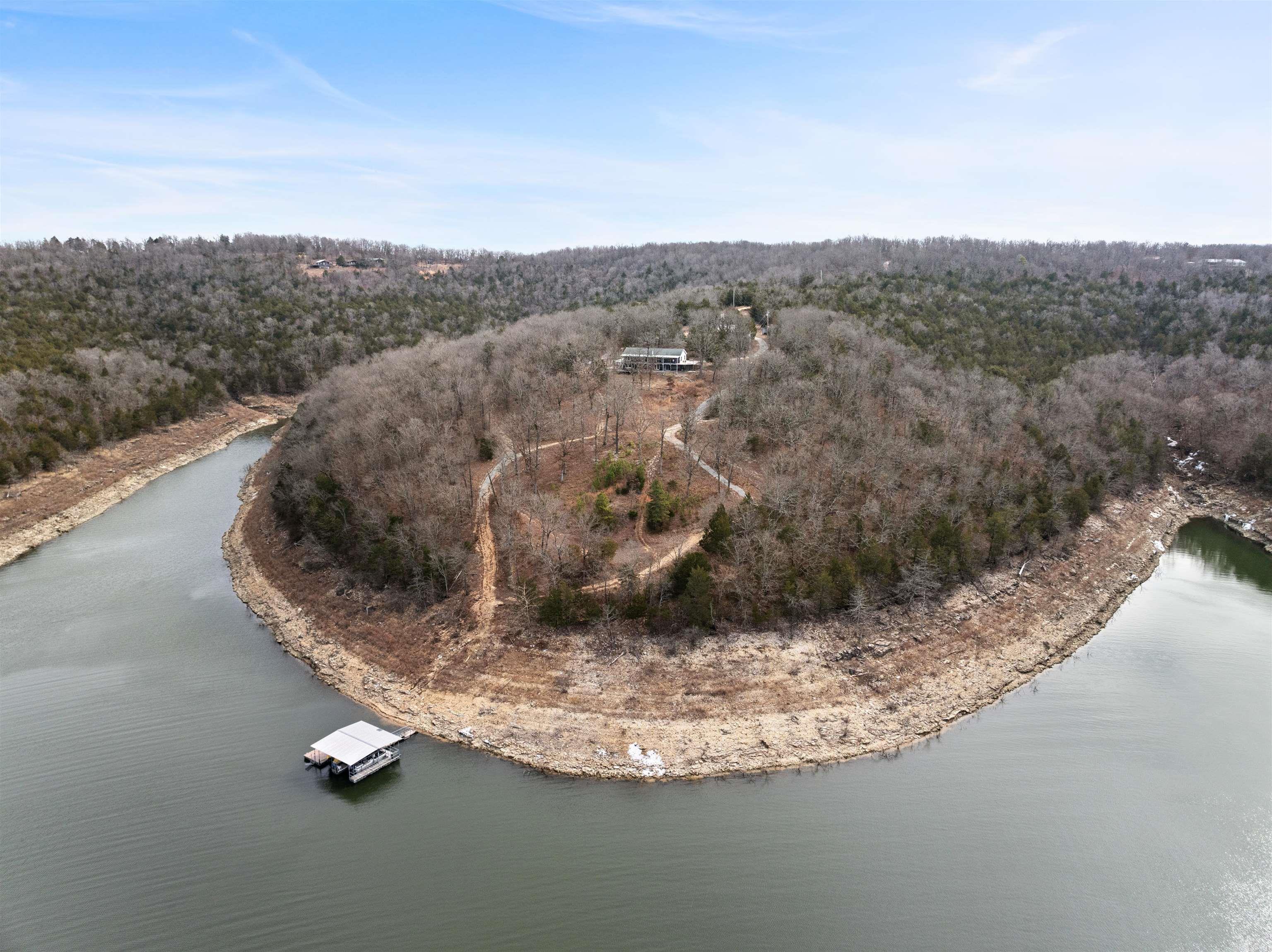 Discover lakefront luxury at 331 Margaritaville Ln, Yellville, AR! This stunning 3 bed, 3 bath home sits on 62+ acres along Bull Shoals Lake with an epic view & a clear sight of your private 2-stall boat dock with lifts. A bonus room in the basement is currently used as a 4th bedroom. Enjoy two hot tubs—one in the basement & one on the back deck. The fully furnished home features a wraparound porch, a walk-out basement with a kitchenette, & a storm shelter. The detached 2.5-car garage includes a studio apartment, plus there’s a carport for winter boat storage. An outdoor shower adds to the charm. Both boats available with an acceptable offer!