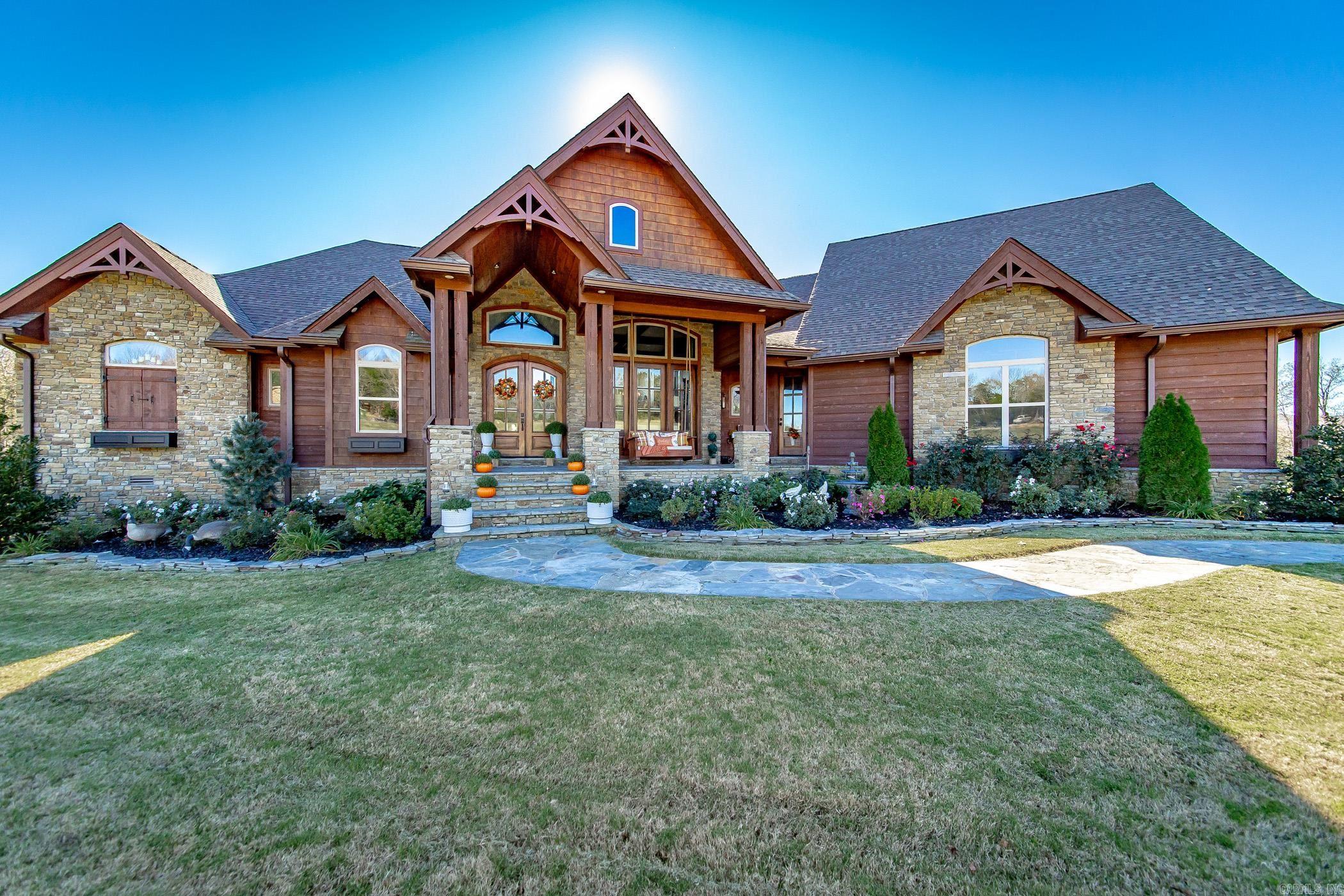 Step into a masterpiece of craftsmanship and comfort at this 4,290 sq. ft. gem, nestled on 1.11 acres at the end of a peaceful cul-de-sac in the prestigious Indian Knob subdivision. Just 2 minutes from downtown Mountain View, this home blends rustic elegance with modern luxury. Exterior Highlights: Stunning western cedar and native stone façade. Picturesque exterior lighting enhancing its charm. Full-house generator for peace of mind. Enclosed porch with an outdoor kitchen, grill, and seated bar for year-round entertaining. Back deck with composite decking for longevity. Interior Features: 5 fireplaces, adding warmth and ambiance. Exquisite architectural details, including: A wood barrel ceiling in the family room, An inverted gazebo wood ceiling in the breakfast area, Custom-built interior doors throughout. Formal living and dining rooms with soaring 21-ft ceilings and a semi-open concept. A sumptuous master suite with custom tile and woodwork, a walk-in closet featuring detailed wood accents and specialty niches, and a spa-like bath. Conveniences Galore: Central vacuum system for effortless cleaning. Two-car garage. 4 bedrooms, 3.5 baths, offering ample space for the family