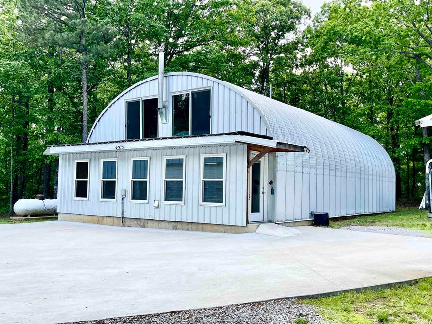 Over 5 acres of privacy and within about 15 minutes of Greers Ferry Lake!  WOW!! Quonset home is 30' X 50' and has 1 1/2 stories with approximately 2200 sq ft of living space! The workshop/boat storage, etc. is even larger - 40' X 58' and also has an upstairs!  House boasts a living room, den/kitchen, 2 BR and 1 bath on main floor and 1 Bedroom and 1 Bath upstairs and space for an exercise room or office! There is a large 2 car carport and 2 large shipping containers for tons of storage! There are 3 mini split units and upstairs has a woodburning stove. Gas water heaters are tankless units and windows are Low-e windows! Shop building is insulated and has water so a bathroom or kitchen could probably be added if needed. Kitchen has beautiful marble countertops. House was built in 2022 and shop building was built in 2024.  You do not want to miss this one!!