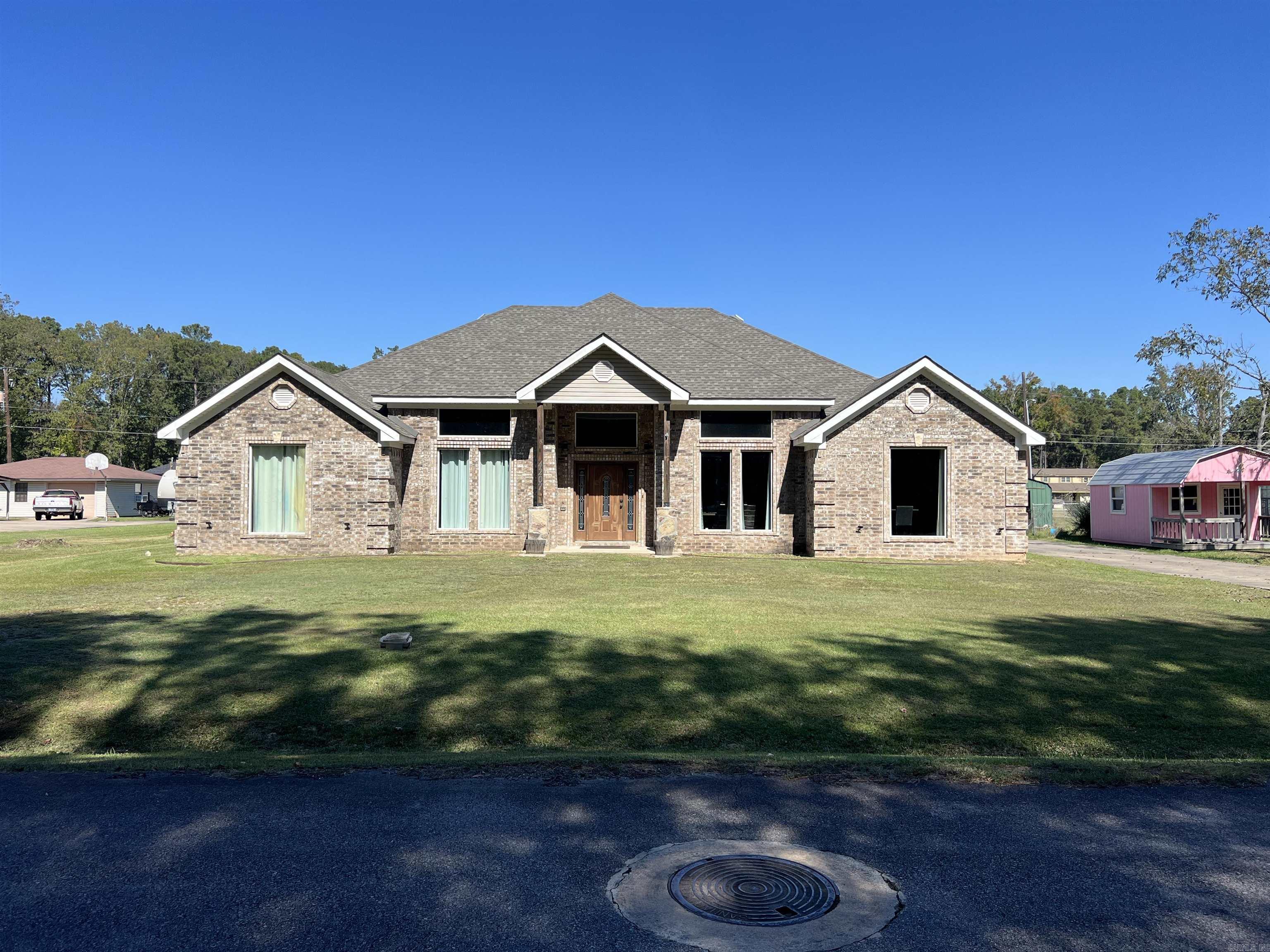 Welcome to this spacious and versatile brick home offering four bedrooms, two full baths, and a fantastic bonus room upstairs currently being used as a game room. The main level features a large eat-in kitchen with an oversized island, breakfast bar, and ample cabinet space, perfect for gatherings and everyday living. A separate dining room adds a touch of elegance, while the large living room showcases beautiful chandeliers and plenty of space for entertaining. The enormous master suite is a true retreat, complete with a garden tub, beautifully tiled shower, and big walk-in closets. A dedicated office provides the flexibility to serve as a fifth bedroom if needed. The large laundry room offers abundant storage, making household tasks easy and efficient. Outside, you’ll find even more to love — an additional home of nearly 700 square feet that’s ideal for guests or a mother-in-law suite. This secondary home includes two bedrooms, one full bath, window units, and a kitchen/living room combo. For the hobbyist or professional mechanic, there’s also a separate workshop equipped with a hydraulic lift. This property truly has it all.