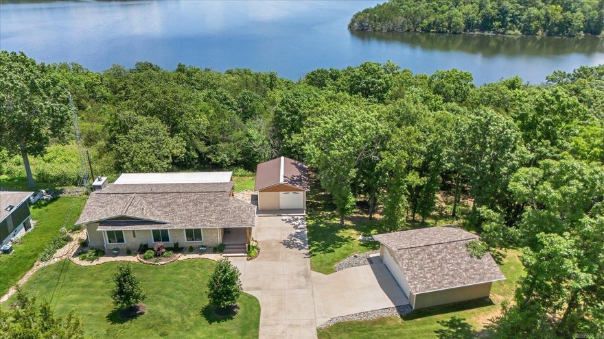 Enjoy year-round views of Norfork Lake from this beautiful 3-bedroom, 2-bath home situated on approximately 0.7 acres across two lots with Corps of Engineers frontage. This well-maintained property features a custom kitchen with Cambria quartz countertops, a cozy wood-burning fireplace with insert, and composite decking perfect for taking in the lake scenery. A new architectural shingle roof was installed in 2021 for added peace of mind. Included is an all-steel, two-slip boat dock with solar power and a swim platform, offering direct lake enjoyment. The property also includes a detached two-car garage with electric, a separate shop with electric, and all appliances convey. Located just minutes from Mountain Home, this lakeview retreat has it all—comfort, convenience, and recreation.