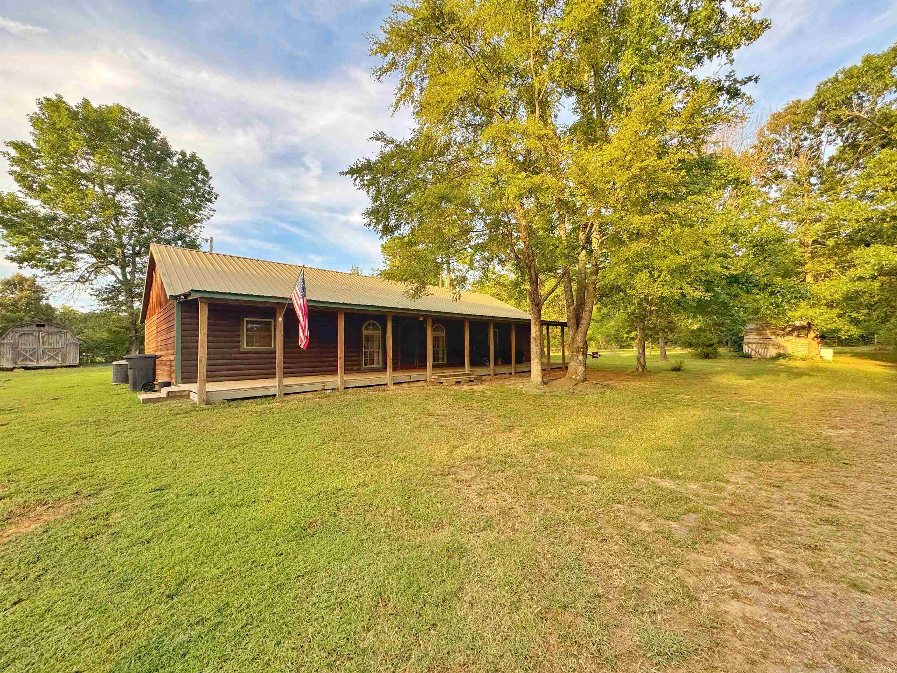 Discover your personal sanctuary tucked into the rolling hills outside Clinton. This charming home perfectly blends rustic Ozark charm with functional comfort with its split floorplan, 3 beds and 2 full baths it is ideal for families of all kinds. There is also a large bonus room off of the laundry room with an exterior door to the back yard which is perfect for a mud room, extra storage, or even a home office. The real magic lies beyond the front door: nearly 20 acres of mixed pasture, woods, and a wet weather pond, fully fenced, all wrapped in the soothing sounds of birdsong and nature. A long winding driveway off a paved county road ushers you to a welcoming covered porch perfect for morning coffee or evening stargazing. Utilities are modern and practical, city water, electric, septic and even two wells (not connected to the home). Just outside the quiet of Clinton, you'll enjoy access to schools, local amenities, and the tranquil beauty of the Ozarks all while relishing the peace of your own rural retreat.