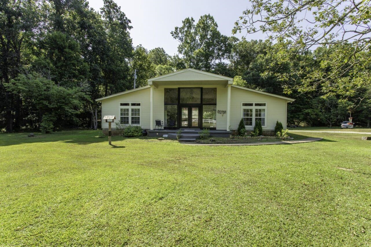 Country Home with 21 acres in Hardy, AR near the Spring River! Peaceful country living just a mile from downtown Hardy and only half a mile from the Spring River! This 2-bedroom, 2-bath home sits on 21 acres in the Ozarks with a creek that runs along the front of the property. Built in 2001, the home features an open kitchen and living area with vaulted ceilings and large windows that bring in tons of natural light. It also includes a covered front porch, a concrete patio in the back of the home. The location and setting of this property are one of the best features! The home sits back off the road with white rail fencing barely visible from the blacktop road. Approximately 15 acres are wooded, offering great deer hunting and room to explore. There is even a small older hunting cabin tucked back on the hillside in the rear of the property that has power. Hardy, AR is one of the gems of the Arkansas Ozarks. In addition to the Spring River, several lakes are within 15 minutes. Lake Thunderbird, Lake Sequoyah & Lake Omaha are some of the favorites.