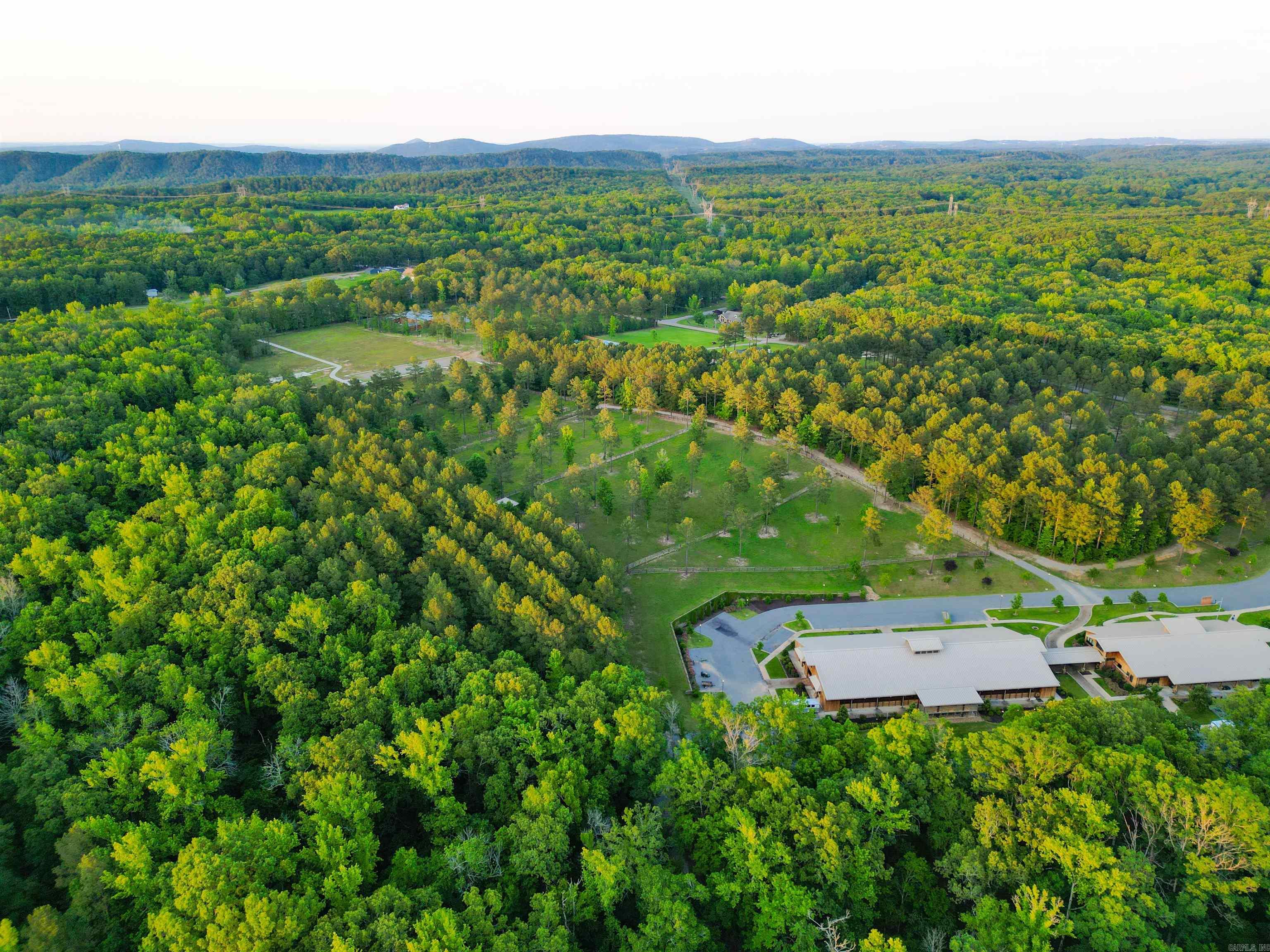 This is an incredible opportunity to have 184 pristine acres in West Little Rock, with 8 miles of well-kept trails and numerous natural surface water creeks, making it a canvas for some incredible development. This gently rolling landscape offers unmatched natural beauty and versatility. The eight miles of professionally maintained trails are wide enough for emergency vehicles and interwoven with creeks and culvert-protected bridges. Whether used for riding, hunting, or home-building, these scenic trails offer abundant wildlife, with frequent sightings of deer, turkey, bobcats, rabbits, and a diverse array of bird species that call this acreage home. This is the only property in Little Rock offering direct access to such an extensive private trail system—ideal for equestrian use, recreational activities, or even nature therapy programs. The neighboring Pine Hill Ranch supports the PATH Certified equine therapy program through the nonprofit Healing Hooves, connecting deeply with the local community. Whether you’re looking to build, expand, or preserve, this property is truly a dream deal. Enjoy this rare expanse of unspoiled Arkansas beauty.