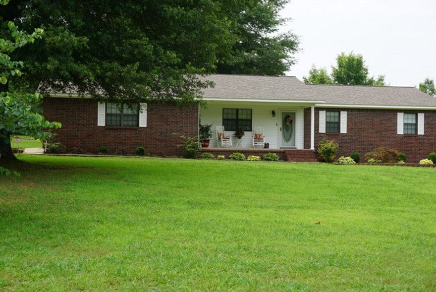 Super Nice Brick home on 7 acres. Lots of trees, nice back patio. Has new sheetrock walls, new wood laminate flooring, fresh paint inside, lots of pretty raised panel custom built cabinets, huge laundry room with a pantry plus a heated and cooled sunroom, has a 30x40 shop, a storm cellar, a separate driveway and separate utilities in place for a MH or another house could be built there. There are a ton of closets in this house. Tile in kitchen and bathrooms. House has alarm. No minerals will convey.