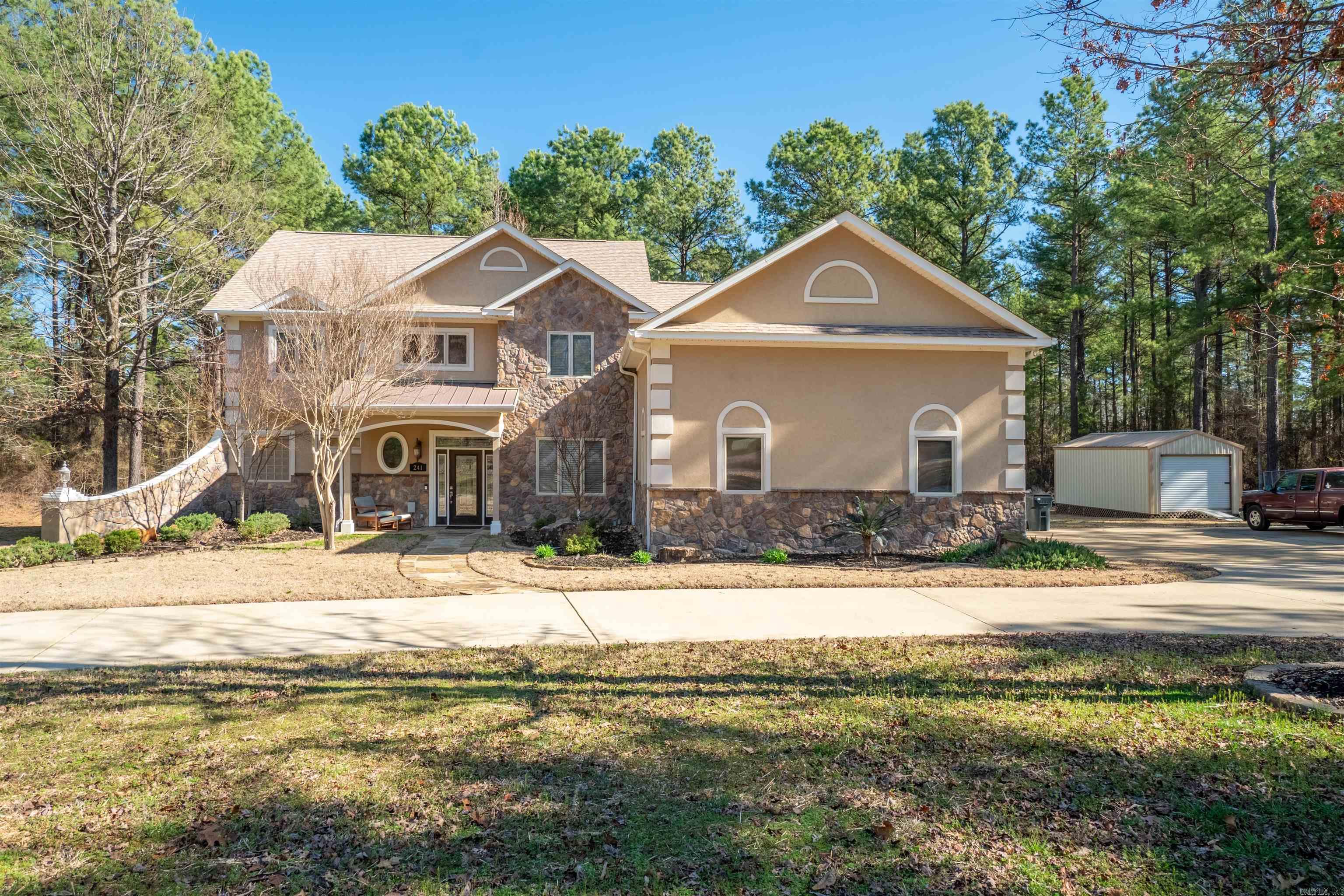 Step into this elegant custom home & be instantly enchanted! Wonderful division of space and space for everyone on your Thanksgiving list - with 5 bedrooms and 4 baths! Some of the special features: large concrete circular driveway, Pergola covered deck; sauna, uplights upper & lower, leaf covers over all gutters: illumination lights in ground (time/date controllable). Inside - family room features rock wall to 26' ceiling with beams; gas log fireplace; recently painted all inside walls. Large chefs kitchen & much more that you will just have to see. This house is just outside Hot Springs Village without HOA dues. Want a garden? Is 3 acres big enough? Primary bedroom/bath on main floor. 3 Bedrooms upstairs. Bonus room/media/work out room located upstairs. Detached 12X25 shed with electricity, and 3 car garage. Beautifully landscaped. SEE AGENT REMARKS