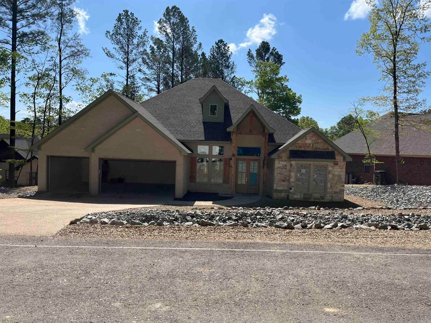 Experience lake living in this beautiful new construction home on Lake Granada in Hot Springs Village, built by Carriage Custom Homes. Designed with an inviting open floor plan, this home offers effortless living and entertaining with thoughtfully selected finishes and quality craftsmanship throughout. The spacious living area flows seamlessly into the kitchen and dining space, creating a bright and welcoming atmosphere. Beautiful finishes, custom details, and large windows bring in natural light while highlighting the peaceful lake setting. Enjoy relaxing mornings and evenings overlooking Lake Granada, a quiet lake known for fishing, kayaking, and swimming. Located inside Hot Springs Village, the largest gated community in the United States, residents enjoy access to numerous amenities including golf courses, lakes, trails, fitness centers, and an active lifestyle community. Whether you're looking for a full-time residence or a peaceful retreat, this thoughtfully designed home offers the perfect combination of modern comfort, scenic surroundings, and active lifestyle amenities. Real estate taxes are based on unimproved lot. Consult tax assessor for tax rate.