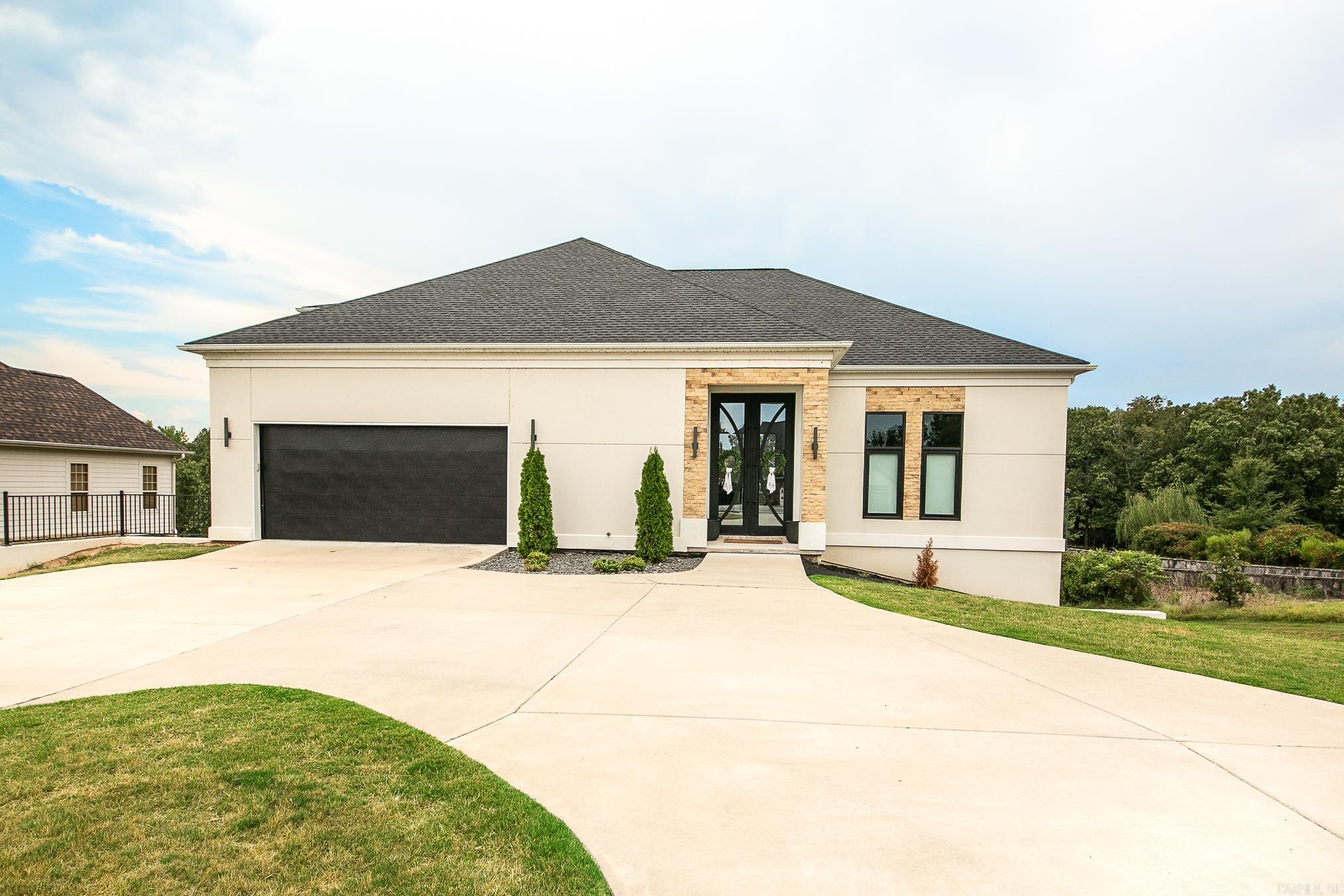 Modern luxury meets functional design in this stunning home located on the water in the sought-after Greystone Subdivision. The main level features a spacious primary suite with floating double sink vanities, a tile walk-in shower, and a relaxing soaker tub. The primary bedroom connects to a private office, which also has access to the living room, where youāll find an electric fireplace for cozy evenings. The sleek, modern kitchen is a showstopper with its waterfall island and breakfast bar, built-in refrigerator that blends seamlessly with the floor-to-ceiling cabinetry, gas cooktop, wall oven, and microwave. Upstairs offers a private retreat with a bedroom and full bath, perfect for guests. The walkout basement is an entertainerās dream, featuring a large open area with a pool table and sitting area, two additional bedrooms, a full bath, a media room, oversized drink fridge, bonus space currently used for a golf simulator, and a workout room that is in the process of being finished out. Enjoy peaceful water views from your own backyard, this home truly has it all.