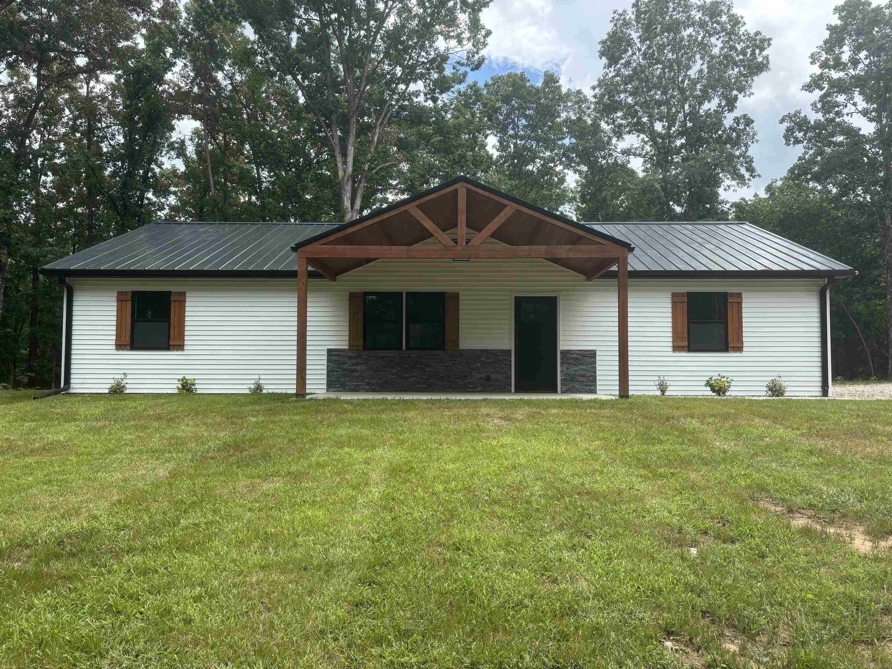 READY, SET, GO!!! Here's your chance to own a Brand-new home in a country setting off a main road!! The home is placed in a wooded setting on 6.5 acres. It features a spacious and open floor plan that blends living and comfort. The main suite highlights a generous walk-in closet and an ensuite bathroom, complete with a tiled shower and dual sinks. Luxury vinyl flooring throughout the home. Kitchen has quartz counter tops and open shelving along with a dedicated pantry and laundry room. The covered back patio is perfect for enjoying the outdoors. The property has cleared trails through the woods and a seasonal stream.