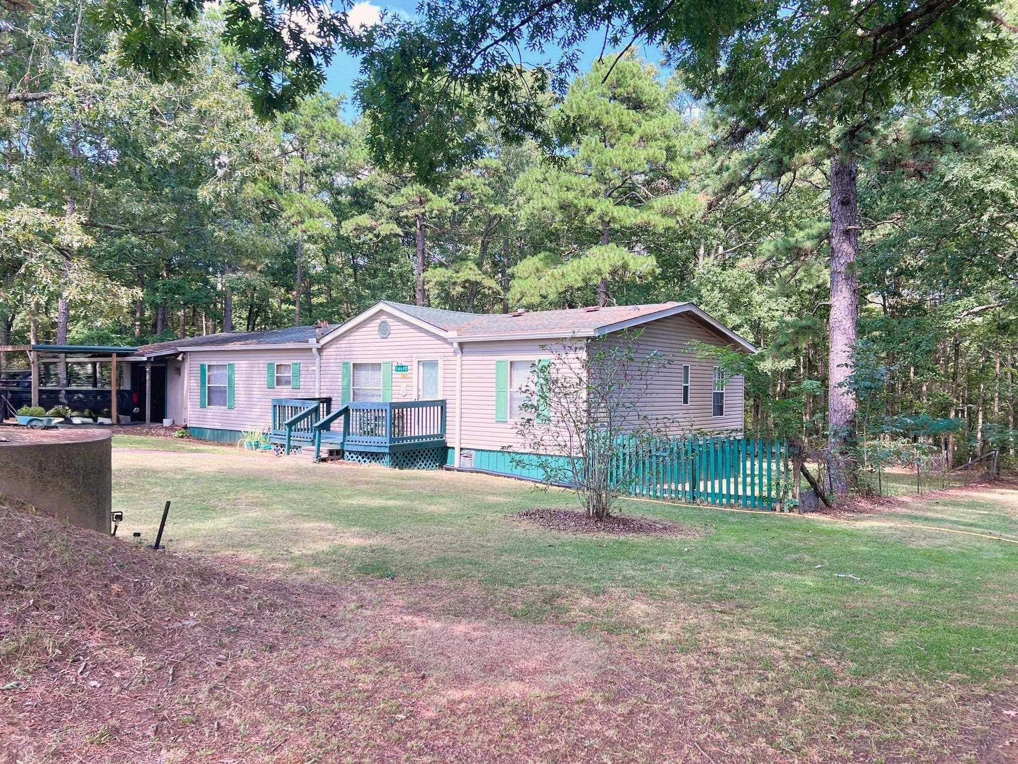 Country Comfort with Privacy & Value ā Move-In Ready! This 3-bedroom, 2-bath double-wide manufactured home sits on a 1-acre lot with a permanent foundation and is ready for a quick sale! Inside, youāll find a split floor plan, a spacious master suite with private bath, a cozy gas log fireplace, and a bright country kitchen with all appliances, including washer and dryer. A dedicated laundry room adds convenience. Furnishing will be available for purchase to make moving in easy. Enjoy the large back deck, where you can take in cool breezes, watch deer and wildlife wander by, and unwind in a peaceful escape from the hustle and bustle. The property includes a 1-car covered carport, garage, storm shelter, detached shed with lean-to, fenced backyard for pets or small livestock, and a 30-amp RV hookup. Thereās also a perfect garden spot ready for your spring planting! With paved road frontage and a peaceful Ozarks setting, this home blends privacy, easy access, and exceptional value. Whether youāre looking for a weekend getaway or your next full-time residence, this ālittle gemā is ready to welcome you home!