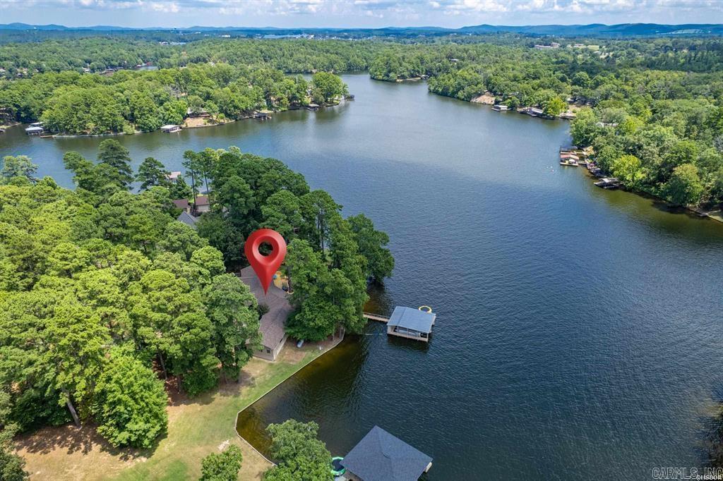 Welcome to your dream lake retreat! This beautifully designed 4-bedroom, 3.5-bathroom lake home offers an open-concept living, kitchen, and dining area, perfect for entertaining or relaxing. As you enter you will immediately be drawn to the lake views! The vaulted ceilings and large living area create a cozy family vibe just waiting for a movie night! This home features a bright and cheerful kitchen designed for both everyday living and entertaining. With vibrant fun finishes, ample counter space, and a gas cooktop, itās the heart of the homeāperfect for hosting family and friends. Right off the kitchen you will enjoy the convenience of a wet bar, ideal for serving up refreshments after a day on the water. The spacious walk-in pantry offers plenty of storage, keeping your kitchen organized. In addition to the four spacious bedrooms, the home features two versatile bonus rooms currently used as additional bedroomsāideal for a home office, exercise room, or extra guests. With dual master suites and two separate living areas on opposite sides of the home, privacy and comfort are thoughtfully considered throughout.
