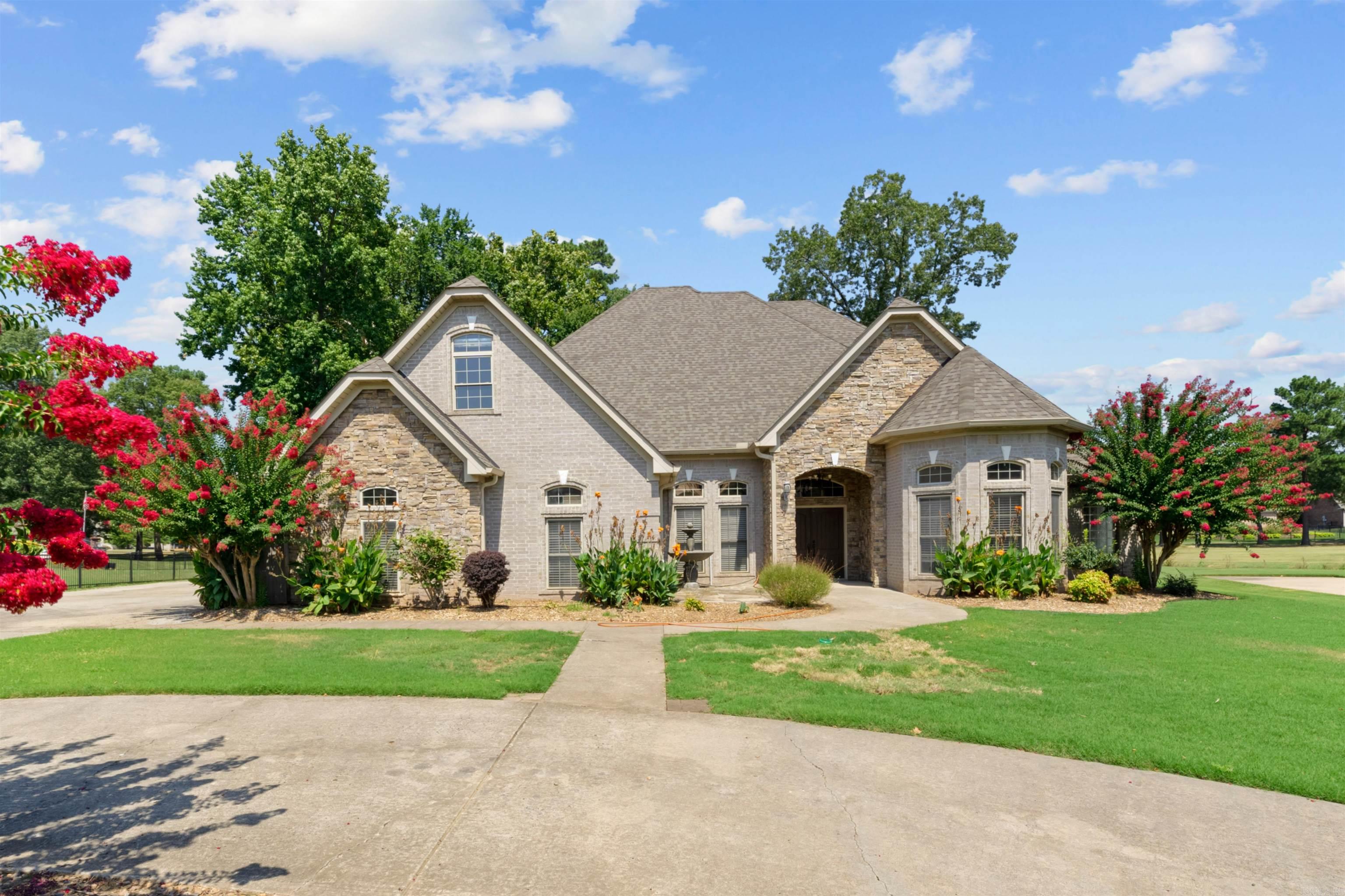 This stunning home offers elegance, comfort, & luxury. Featuring a 4 car garage w/a safe room constructed w/a one hour firewall. Inside the home boasts 12' ceilings, large living, sep dining, perfect for entertaining. The chef's kitchen is equipped w/breakfast bar, Corian countertops, stainless appliances, a butler's pantry & an adjoining breakfast nook. A double sided fireplace warms both the living & enclosed sunroom which is designed w/tempered glass for peace of mind. The master suite is a true retreat, w/dramatic double tray ceiling, walk-in closet, & a spa-inspired bath w/a corner jetted tub, his/her vanities & sep shower. 4 bedrooms down & 1 private bedroom & full bath up. Outdoors is just as impressive w/covered patio w/fireplace overlooking the golf course. This home combines sophistication, safety, & comfort in one remarkable package. YOU DON'T WANT TO MISS THIS ONE!