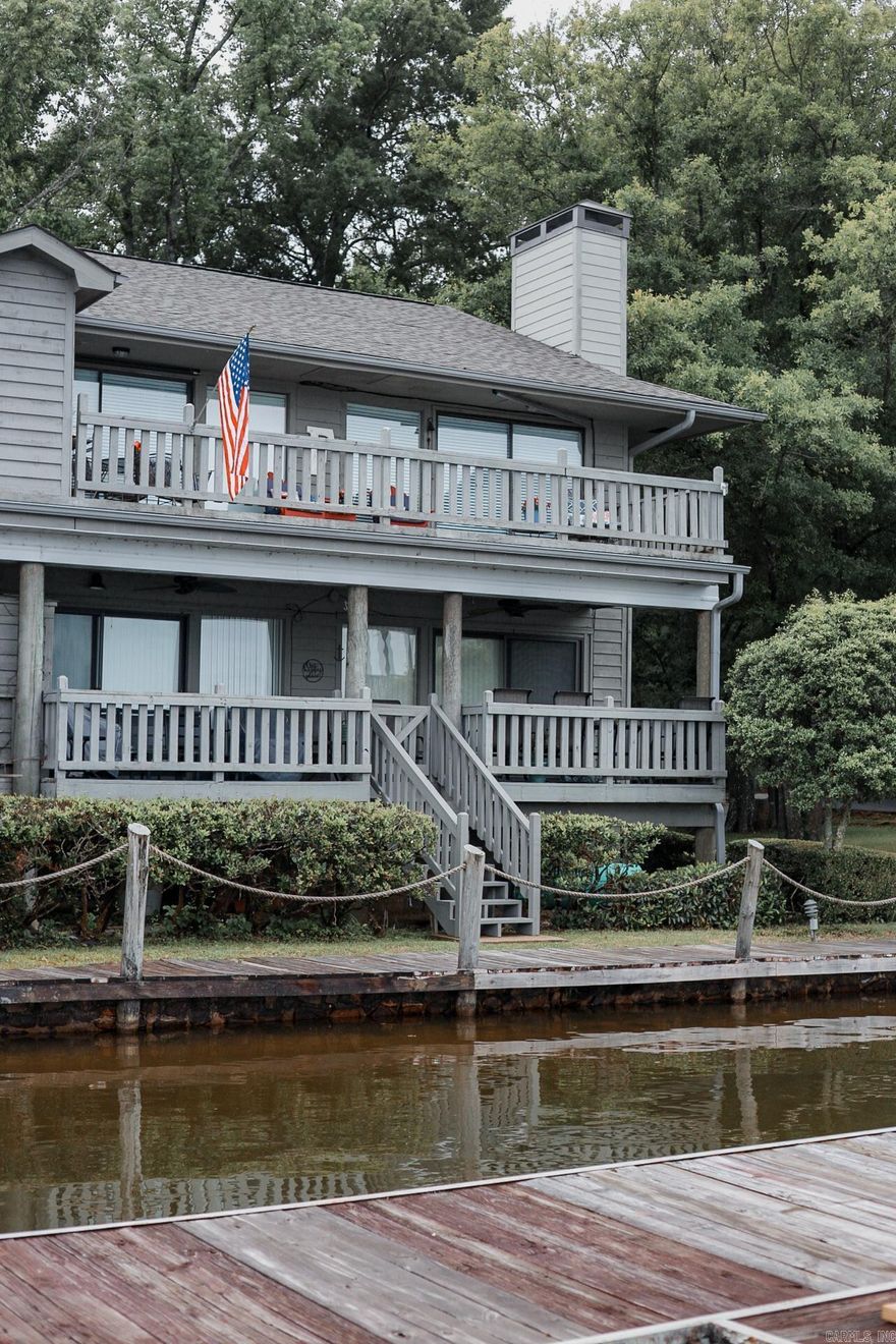 Lakefront 2 bed, 2 bath condo located on the second floor in a quiet, relaxing setting. Spacious bedrooms and updated luxury vinyl flooring throughout. The layout works out well for full time living, weekend getaway, or investment opportunity, making it a great year-round property.  Enjoy direct lake access with a private covered, gated boat slip and jet ski slip. The views are a standout feature of this property, with two balconies offering plenty of outdoor space to relax or entertain. Inside, a wood burning fireplace adds to the comfort and character of the space, and there is also a community pool.  Conveniently located approximately 15 minutes from Oaklawn and downtown activities, while still offering a peaceful, retreat-style environment.  Sold furnished (agents see remarks for exclusions).