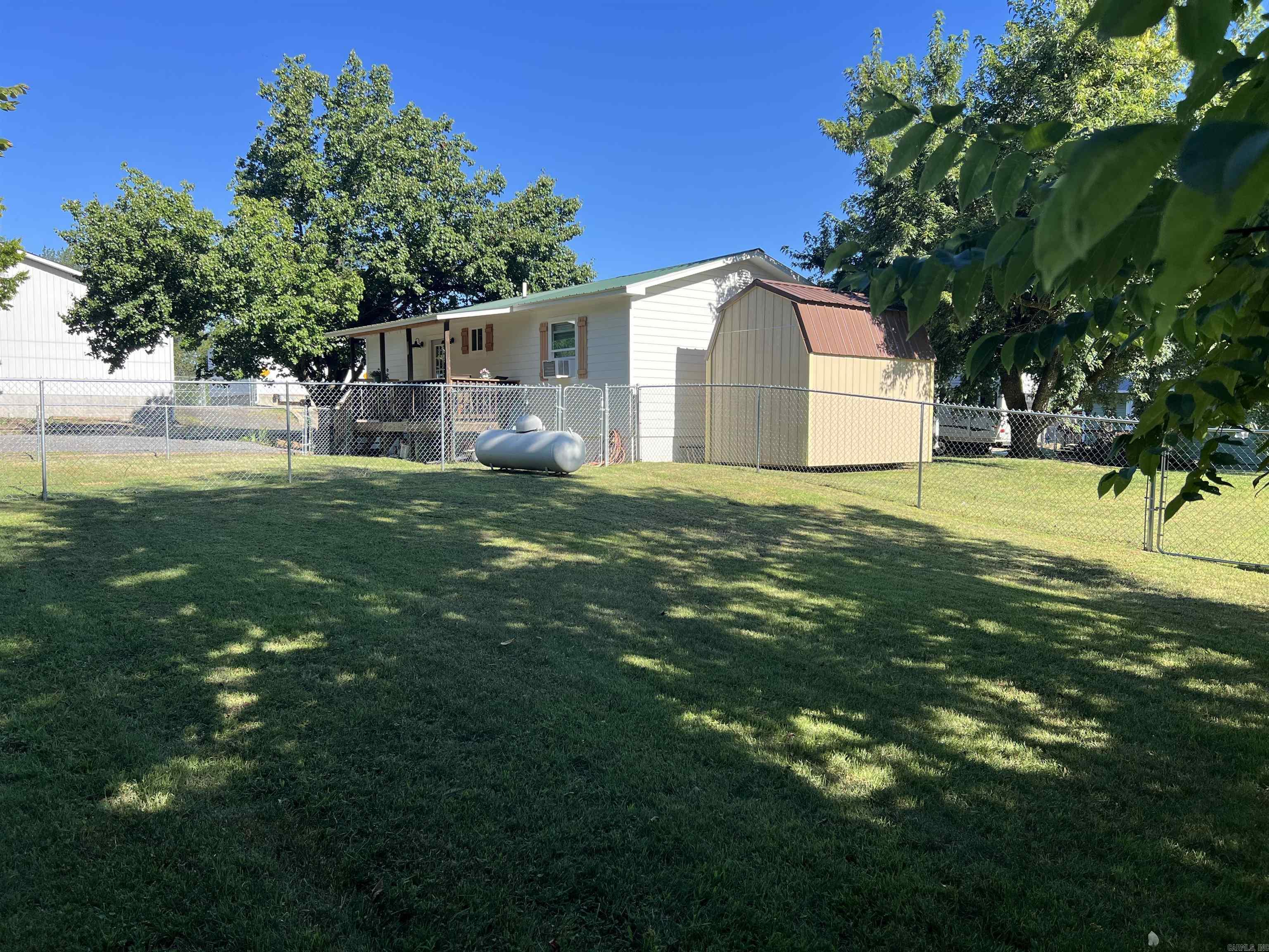 Charming 2-bedroom, 1.5-bath home located at 103 Lynn St., Marshall, AR 72650, featuring a spacious 16x30 workshop that could be converted into additional living space or a game room, plus an 8x12 storage building for extra storage. The home and 16x30 building are heated and cooled by ductless mini splits. The covered deck overlooks the spacious yard with two chain-link fenced areas, perfect for pets or children to play safely. Conveniently located within walking distance to the city park, fishing pond, grade school, library, and courthouse square, and just 15 minutes from the Buffalo National River for kayaking, hiking, and outdoor recreation, this property would make a great full-time residence, rental, or VRBO investment.