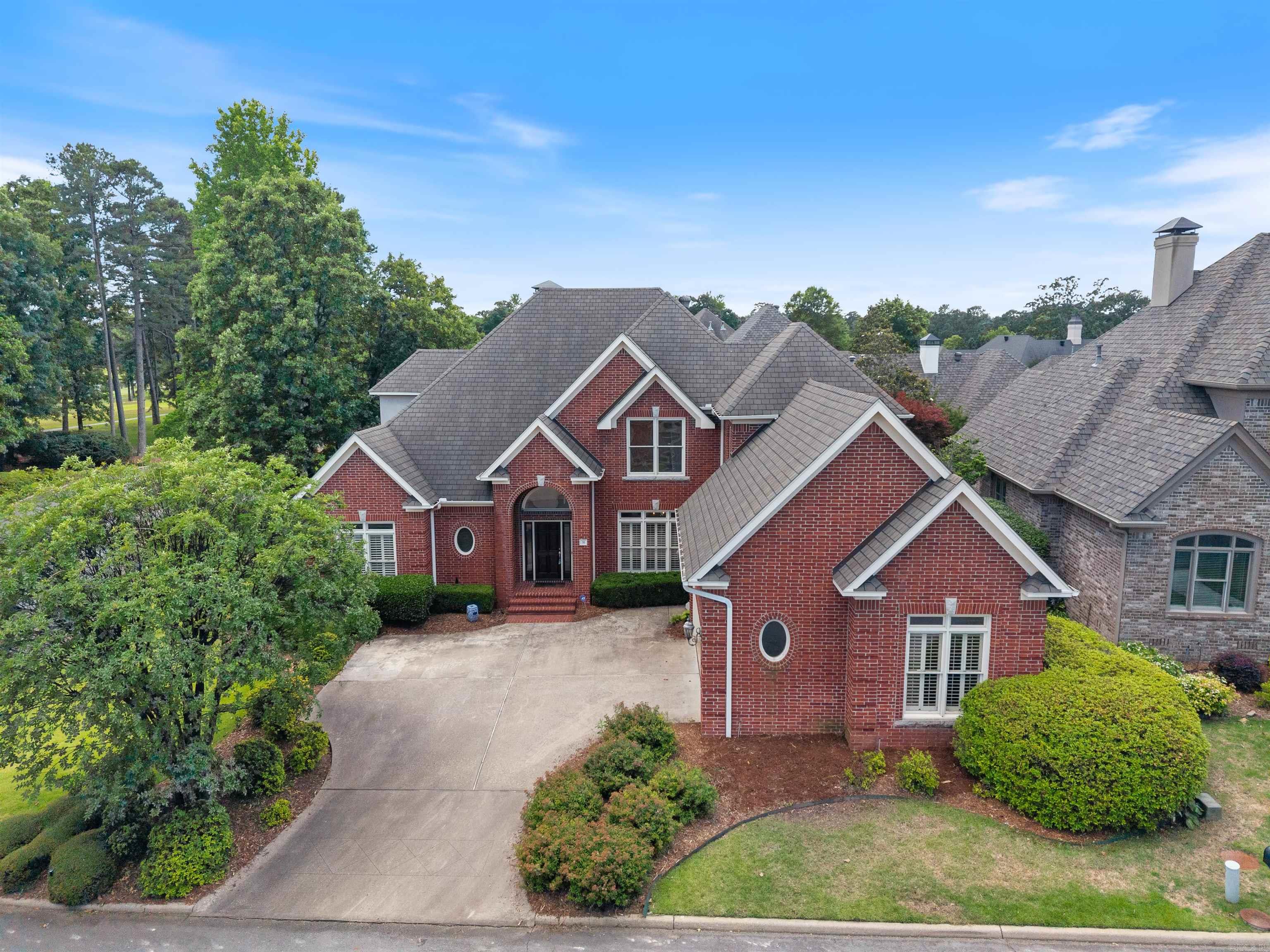Welcome to 31 Alba Lane, a beautifully appointed home in a gated community near Chenal Valley Country Club. Set on a desirable corner lot, this residence blends comfort, elegance, and convenience. Rich wood flooring flows through an open, light-filled layout. The formal dining room features plantation shutters and timeless details, while the vaulted living room offers a balcony overlook, gas fireplace, and built-in wet bar with mini fridge. The gourmet kitchen includes granite countertops, Frigidaire range top and double ovens, GE dishwasher, LG microwave, Whirlpool ice maker, breakfast bar, built-in desk, and a spacious eat-in area. The main-level primary suite offers a spa-like bath with soaking tub, double vanities, private water closet, and walk-in closet. An additional guest suite on the main level offers flexible use as a private office or an inviting retreat. Upstairs, 2 bedrooms share a full bath, along with a versatile bonus room. A large storage closet also provides ample space. Outside you can enjoy the covered back patio and mature trees. Extras include a two-car garage with golf cart bay, storage, outdoor cameras, and security.