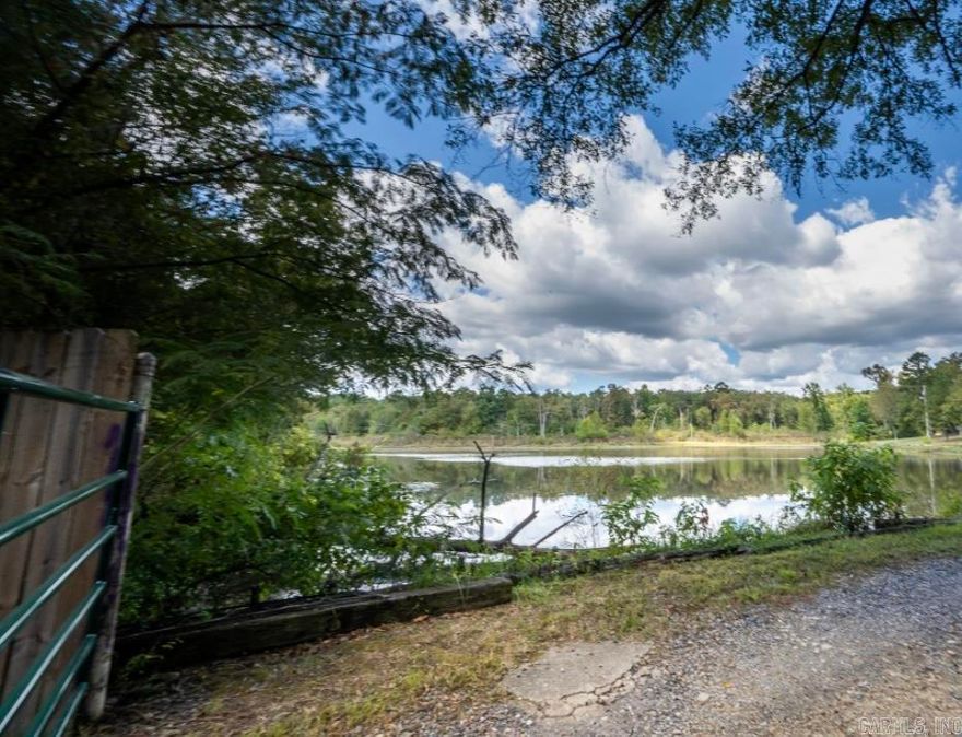 Must See Listing! This property is wooded overlooking a large pond on paved county road just out of Mena, AR close to Wolf Pen Gap Trails.  Build your dream home or getaway cabin. New survey reflects part of pond is on this gorgeous wooded property. (Beautiful building side on hill overlooking pond)