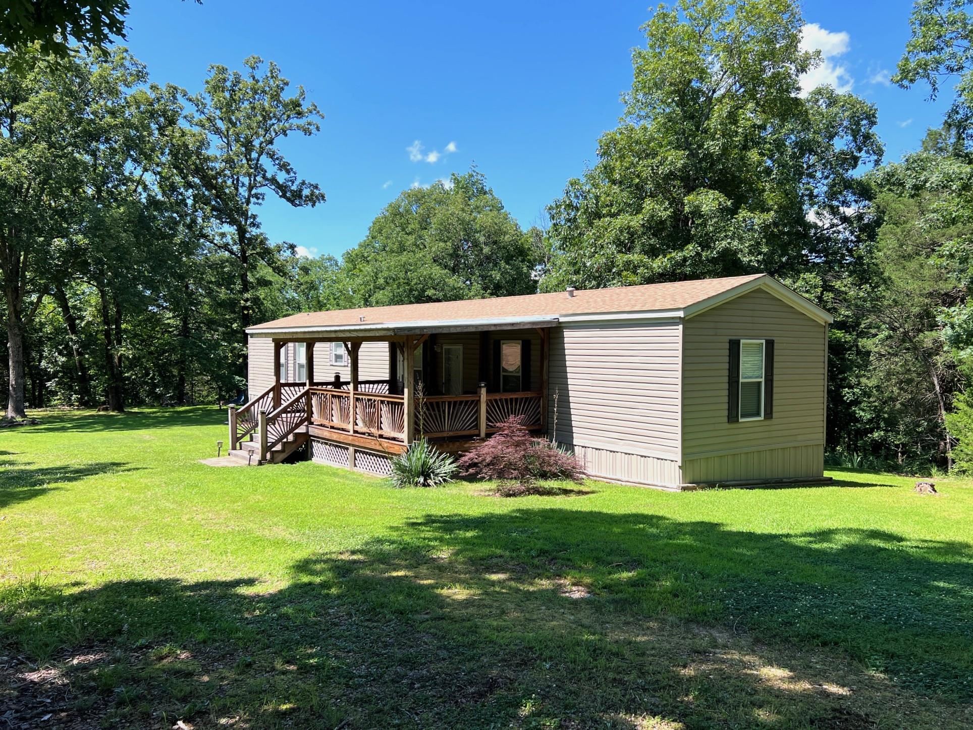 Tucked-Away Mountain View Retreat w/Cabin-Style Studio & Nearly 5 Acres At the end of a quiet road just outside Mountain View city limits, this charming 3-bed/2-bath mobile home offers the perfect balance of privacy, convenience, & opportunity. Set on 4.96 wooded acres w/underground utilities, this home has been lovingly used as a vacation getaway & is move-in ready—most furniture included! The home features a 2023 metal roof, tilt-out double-pane windows, updated siding, and central HVAC via a modern heat pump. Inside, it’s cozy & functional, w/all appliances conveying, including washer & dryer. Step outside & discover the real gem: a versatile shop/studio building w?a concrete floor, power, water, & its own half bath. Half is finished & insulated w/a kitchen sink & wood stove flue—ideal for a creative studio, music space, guest quarters, or future rental. The other half offers excellent storage or garage use w/workbenches & shelving already in place. Located just 5 mins from downtown, you're close to the Ozark Folk Center, world-class White River fishing, kayaking, & seasonal events. This dream—offers space to grow & imagine. Call & visit today!